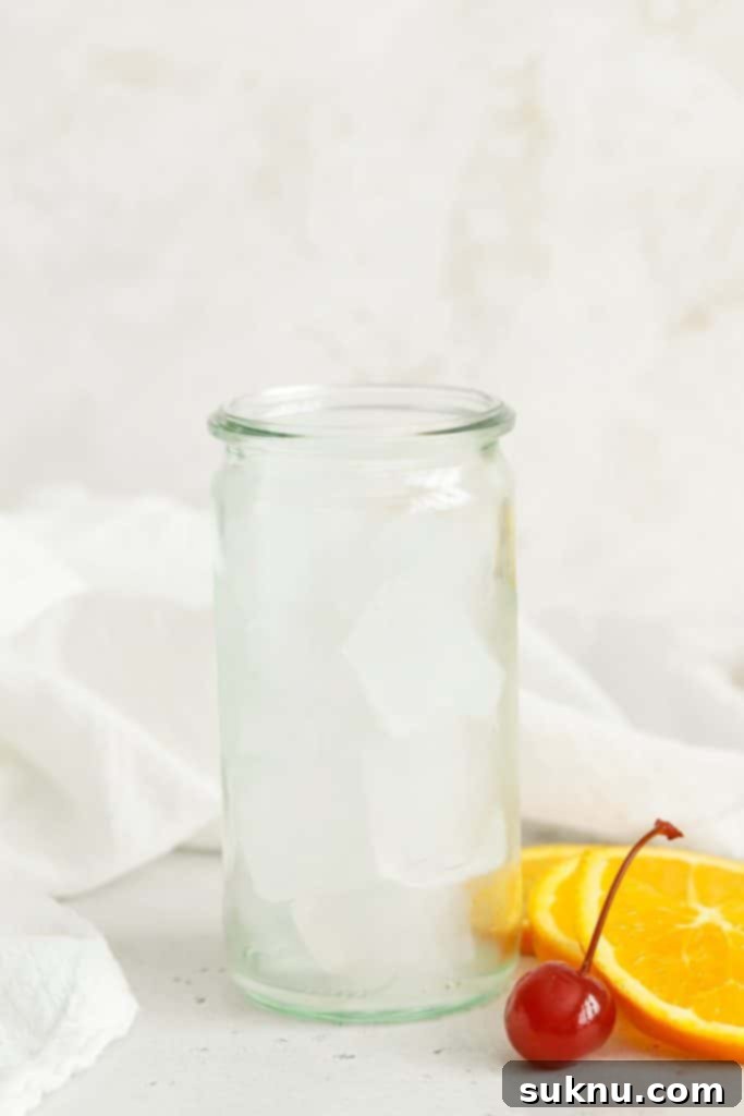 A glass filled with ice, ready for a delicious orange juice grenadine mocktail