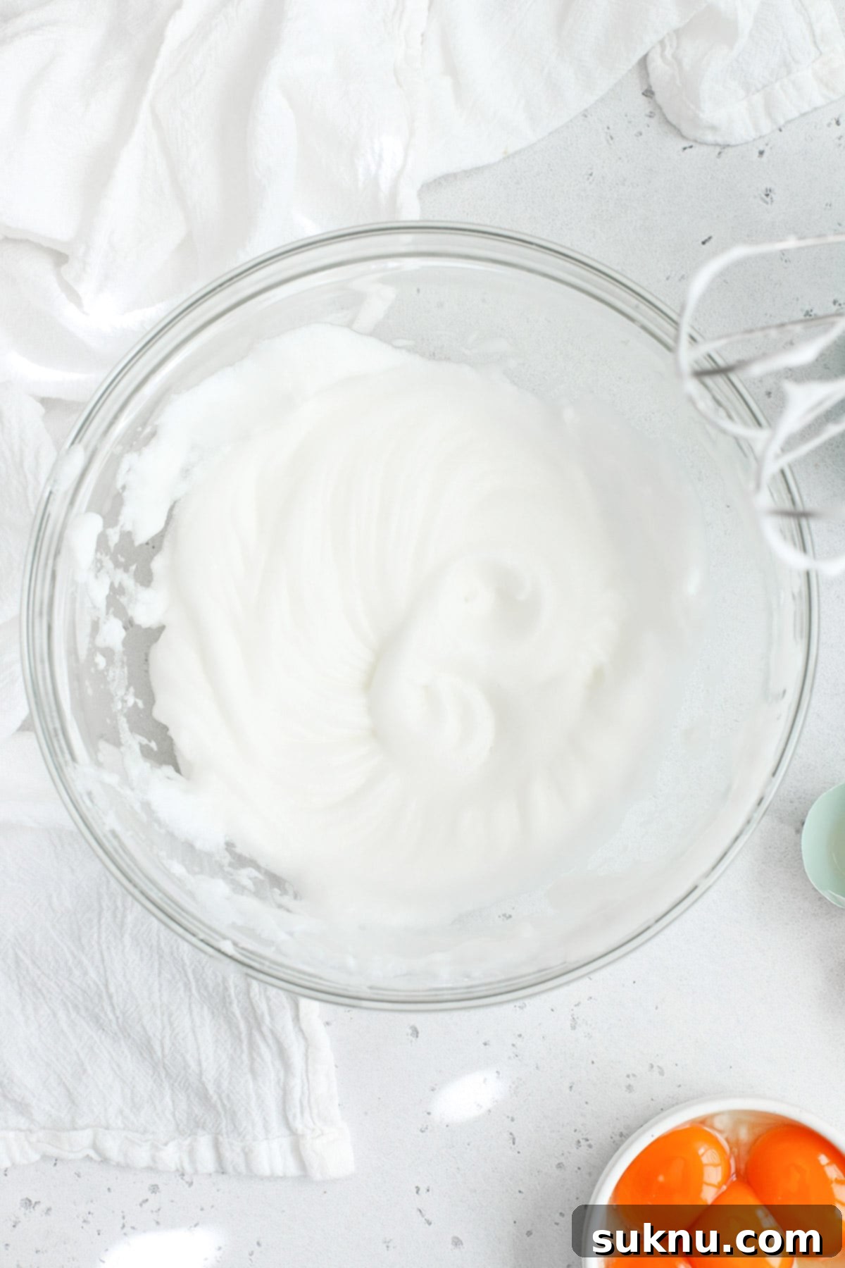 Mastering Whipped Egg Whites: Stiff and Soft Peak Techniques 2 Overhead view of egg whites whipped to soft peaks in a glass bowl