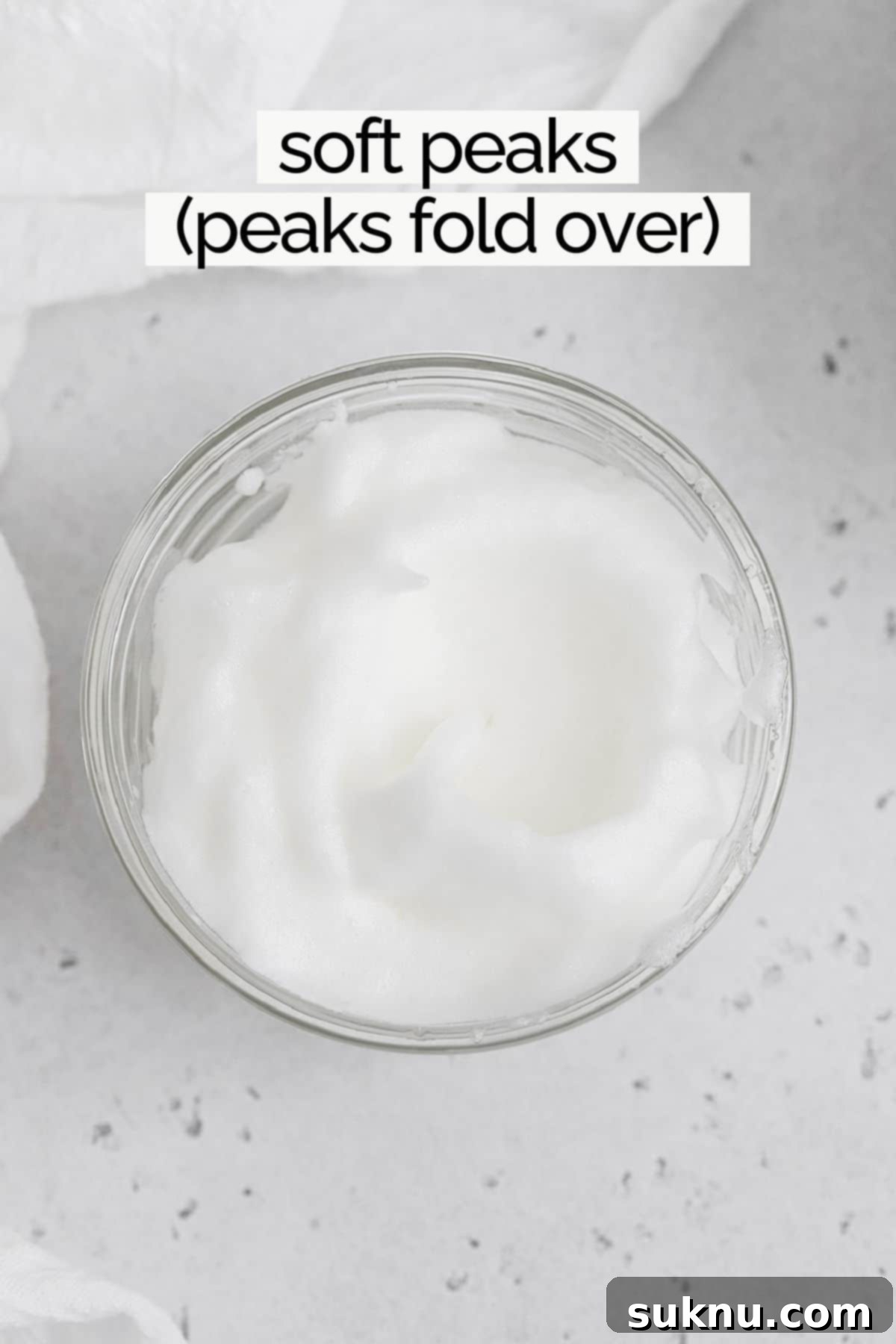 Mastering Whipped Egg Whites: Stiff and Soft Peak Techniques 7 Overhead view of egg whites whipped to soft peaks in a clear bowl