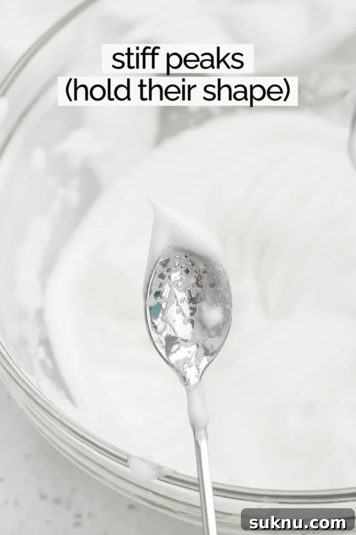 Mastering Whipped Egg Whites: Stiff and Soft Peak Techniques 8 Egg whites whipped to stiff peaks on the end of a spoon, showing firmness