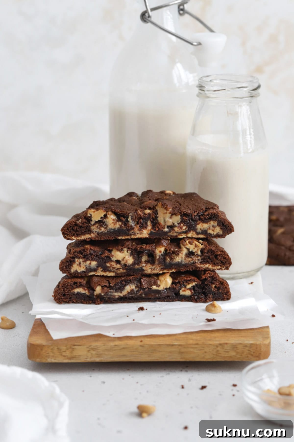 Front view of ultimate gluten-free Levain-style dark chocolate peanut butter chip cookies, revealing their gooey center