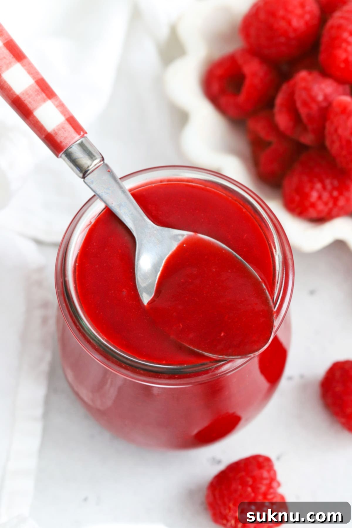 Vibrant Raspberry Coulis 2 Front view of fresh raspberry coulis in a jar