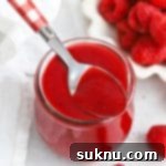 Vibrant Raspberry Coulis 11 Front view of fresh raspberry coulis in a jar