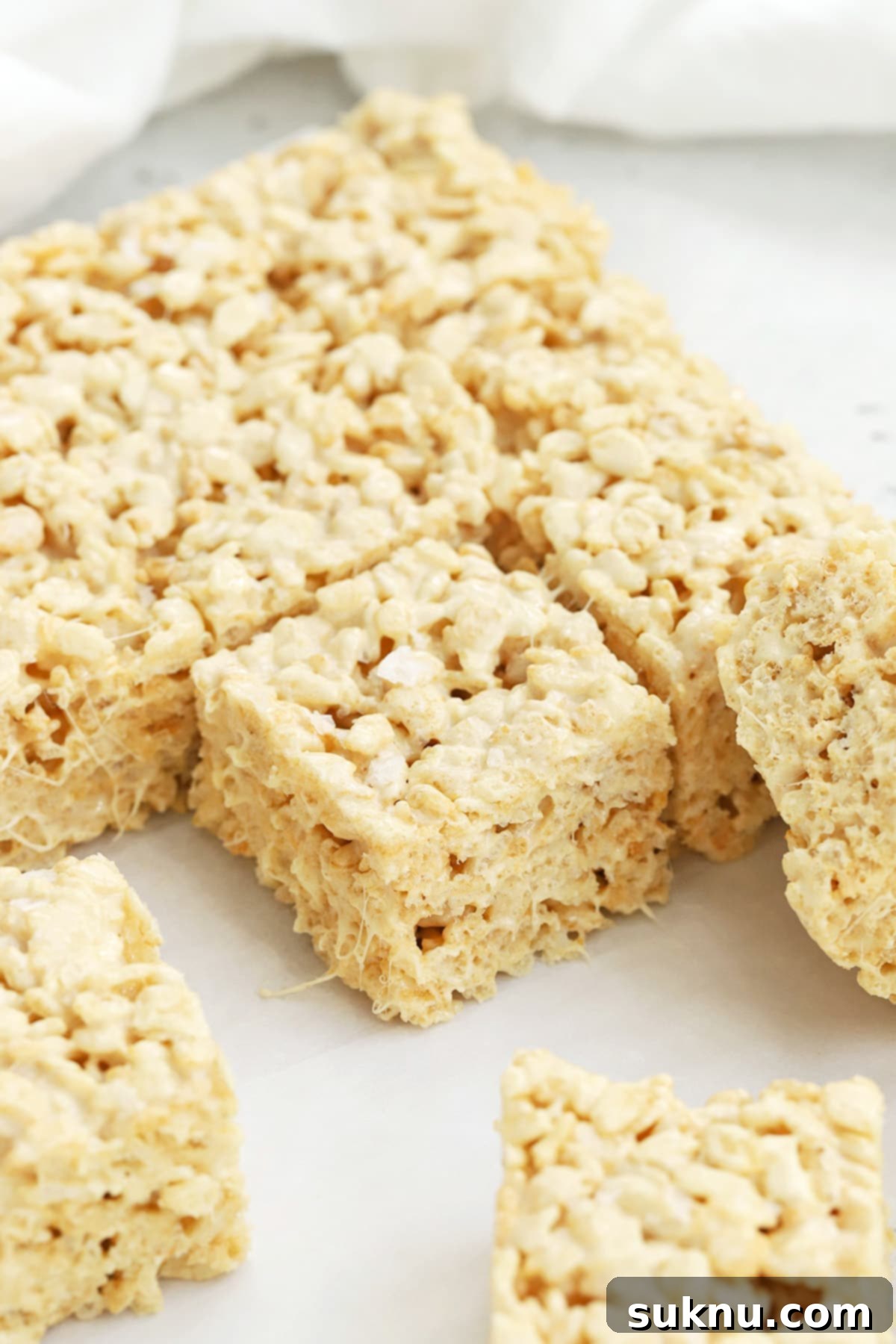 Perfectly cut squares of gluten-free brown butter rice krispies treats arranged neatly on a serving platter.