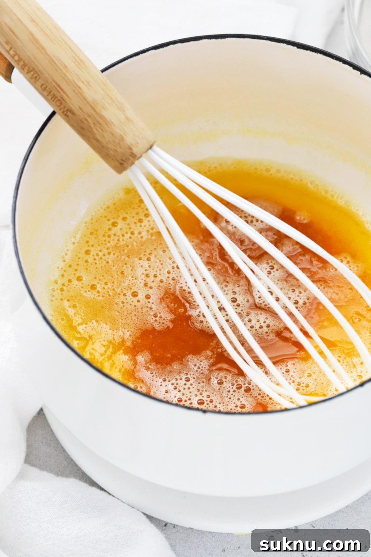 Overhead view of butter browning in a saucepan, showcasing the golden color and nutty aroma beginning to develop.