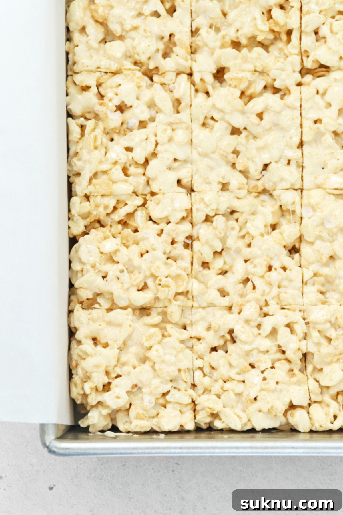 Freshly cut squares of gluten-free brown butter rice krispies treats, showing their soft, chewy texture and even distribution.