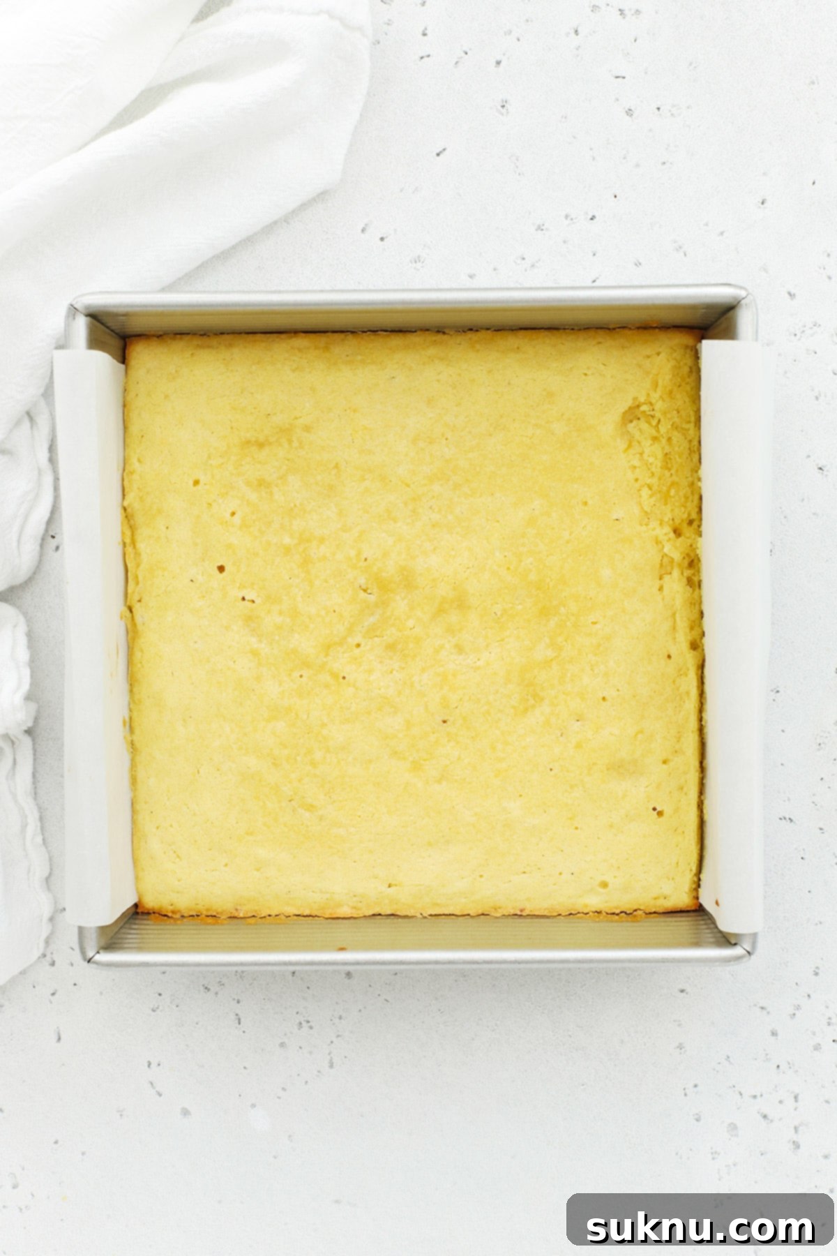 Freshly baked gluten-free lemon brownies, golden brown and perfectly set in the baking pan, cooling before glazing.