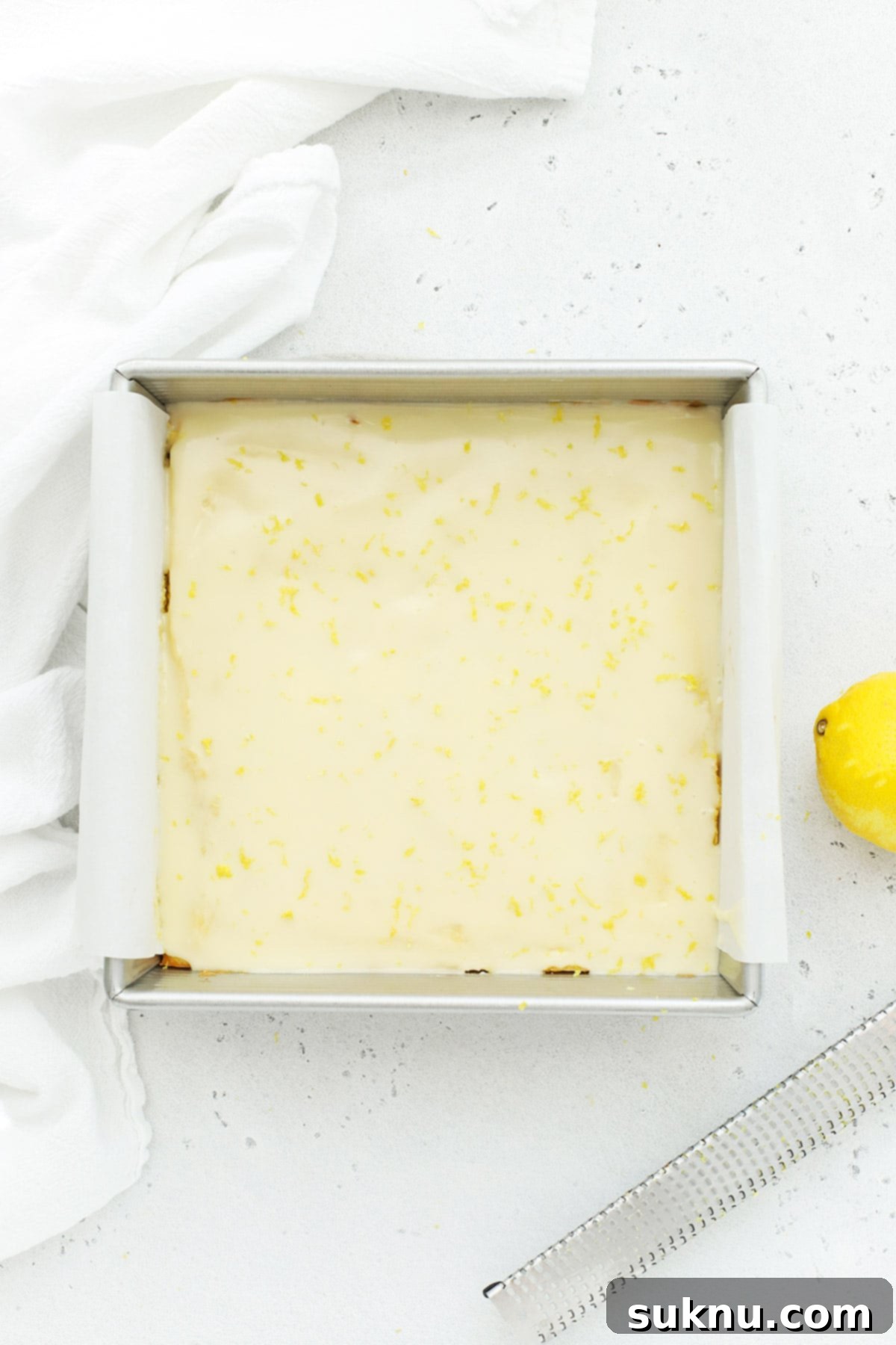 Glazed gluten-free lemon brownies, covered with a smooth, glossy lemon icing and ready to be sliced and served.