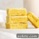 frosted gluten-free lemon brownies stacked on a white plate