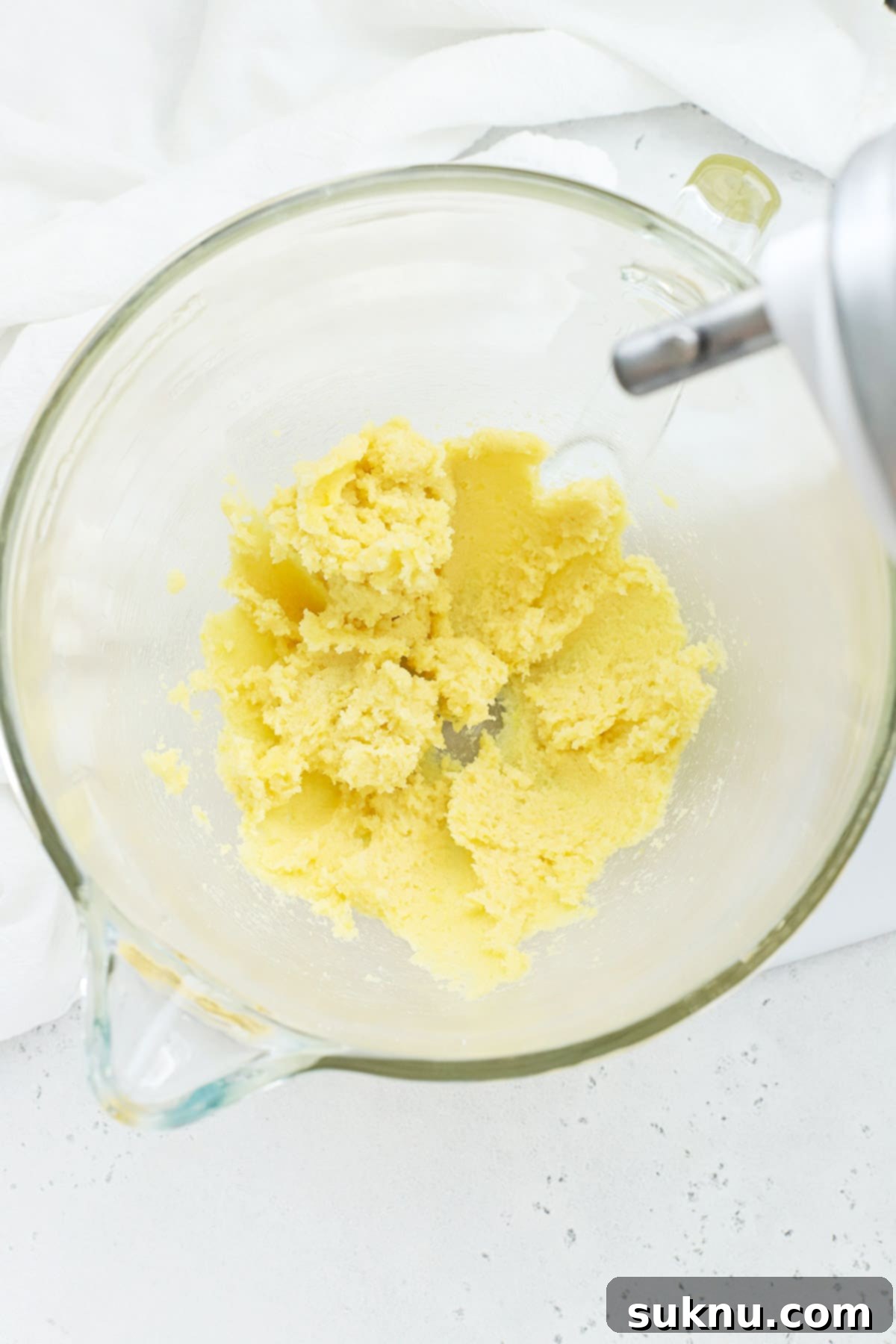 Creamed butter and sugar with lemon zest, showing a light and fluffy texture, prepared for the next step in making lemon brownies.