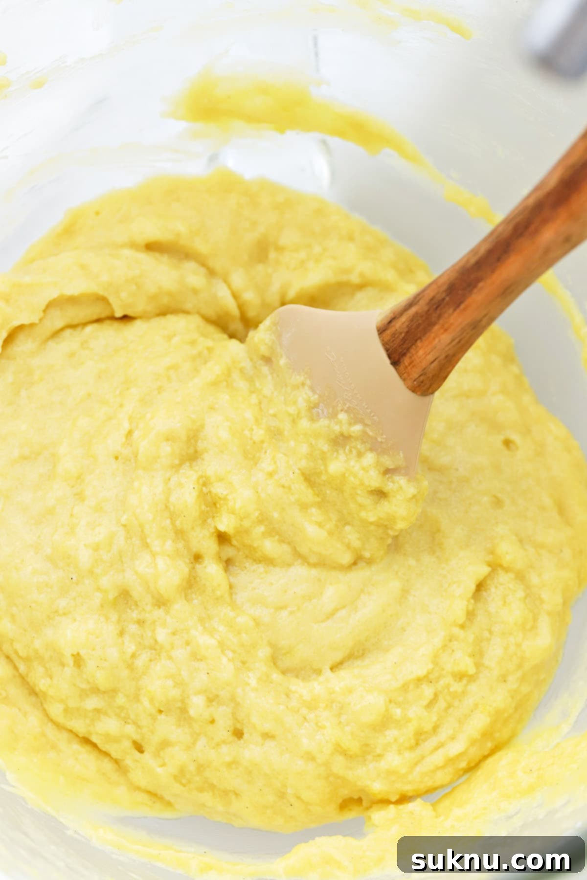 Gluten-free lemon brownie batter being mixed until just combined, showcasing its smooth, thick consistency.