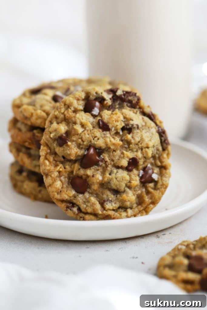 Gluten-Free Oatmeal Chocolate Chip Cookies stacked on a white plate, showcasing their inviting texture.
