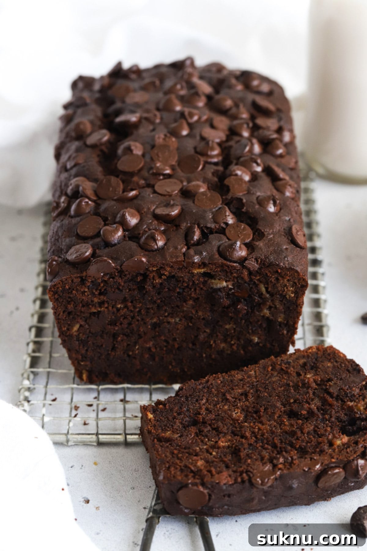 Decadent Gluten-Free Chocolate Banana Bread 16 Front view of a beautifully baked loaf of one-bowl gluten-free chocolate chocolate chip banana bread, presented on a cutting board, ready to be sliced and savored.
