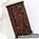 Decadent Gluten-Free Chocolate Banana Bread 18 Overhead view of a freshly baked loaf of gluten-free chocolate banana bread with chocolate chips, ready to be served.