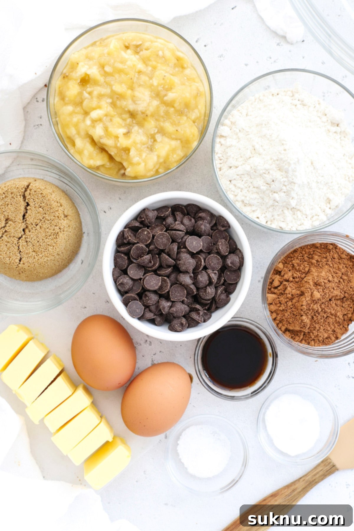 Decadent Gluten-Free Chocolate Banana Bread 4 Overhead view of the precisely measured ingredients for gluten-free chocolate banana bread, neatly arranged on a rustic wooden surface before combining.