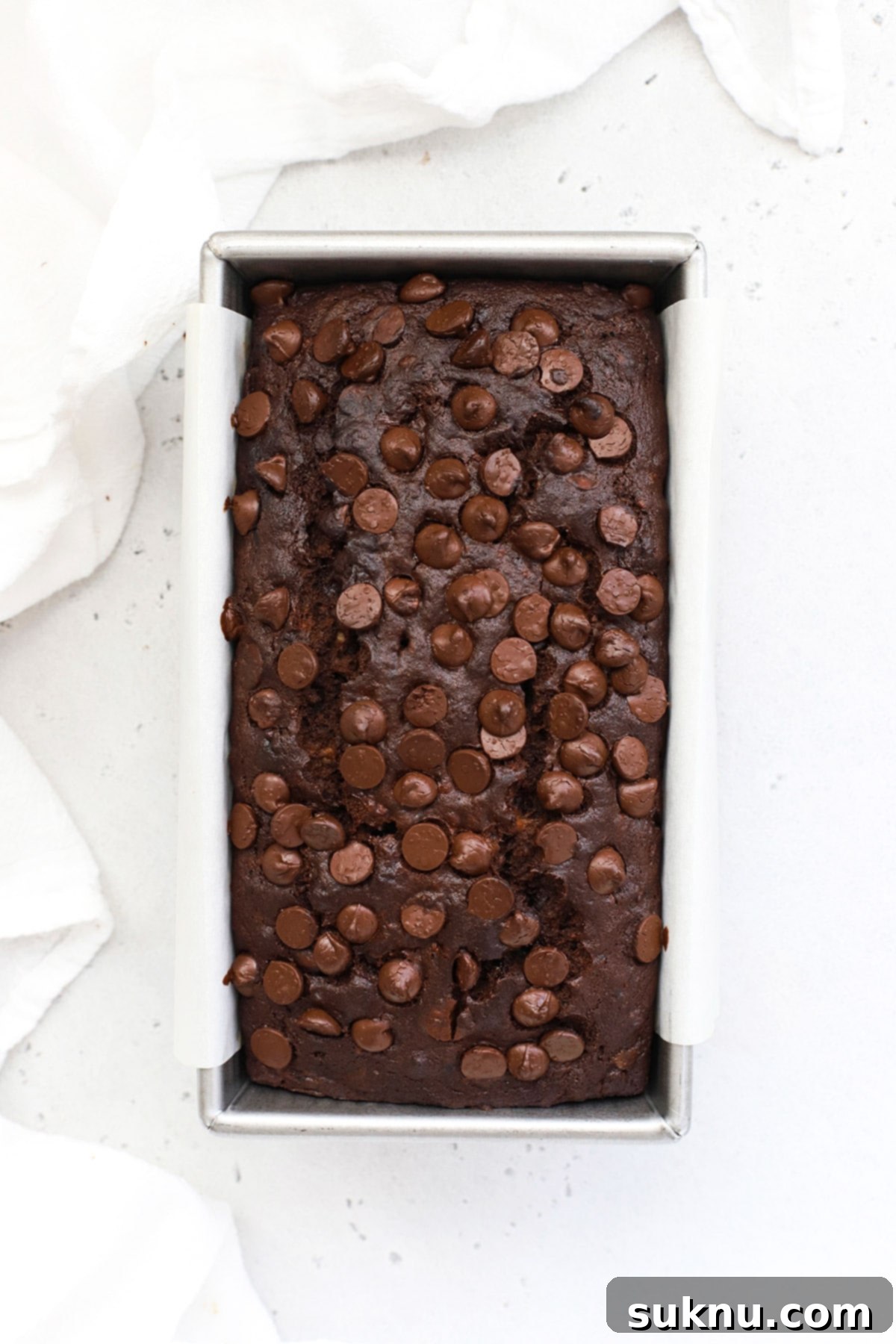 Decadent Gluten-Free Chocolate Banana Bread 10 Another overhead perspective of the unbaked gluten-free double chocolate banana bread, emphasizing the smooth surface of the batter and the generous placement of chocolate chips before baking.