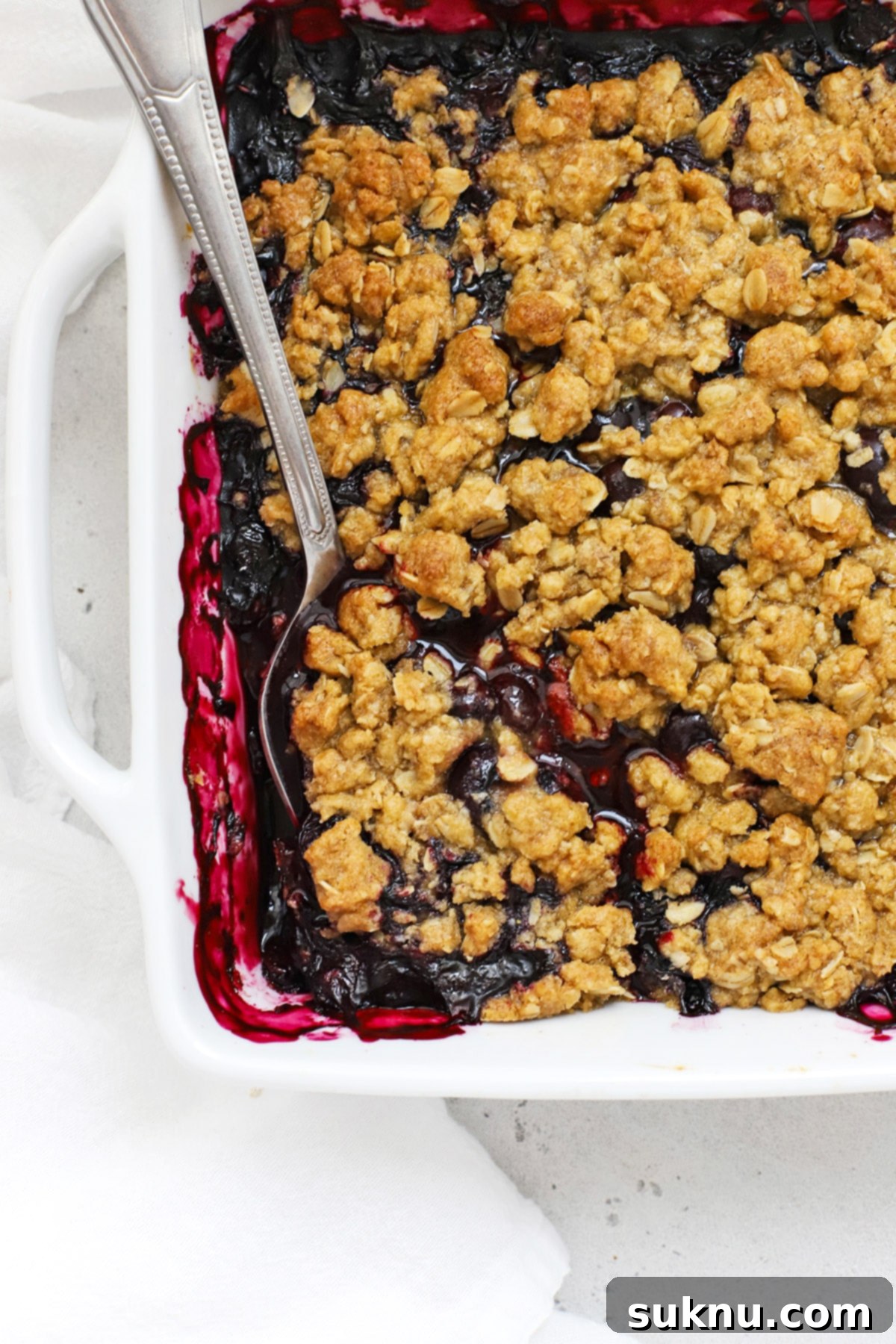 An overhead shot of a freshly baked pan of gluten-free blueberry crisp, with the golden-brown crumble topping visible.