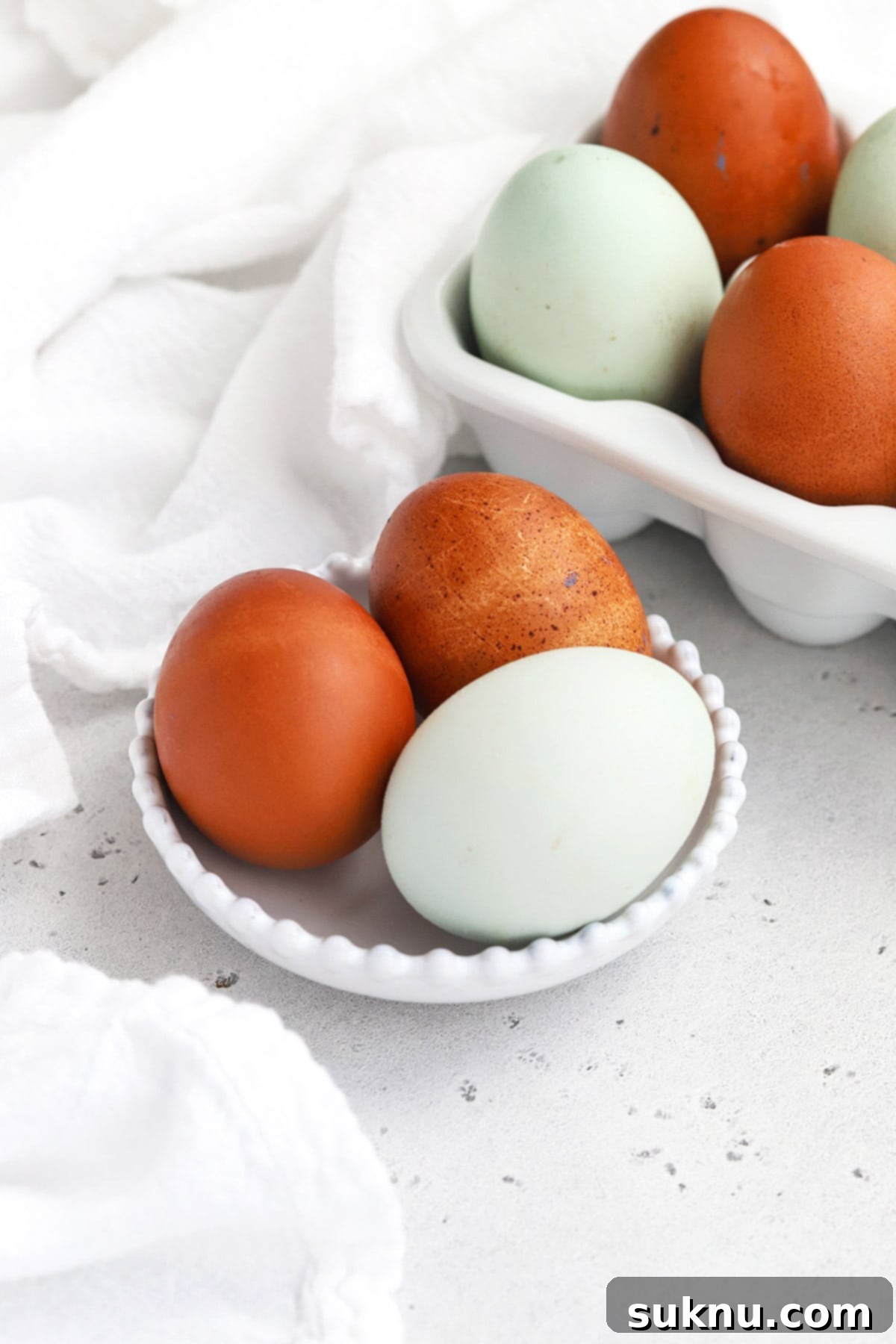 Unlock Room Temperature Eggs in Minutes 2 Front view of 3 multicolor farm eggs in a bowl, ready to be warmed to room temperature for baking.