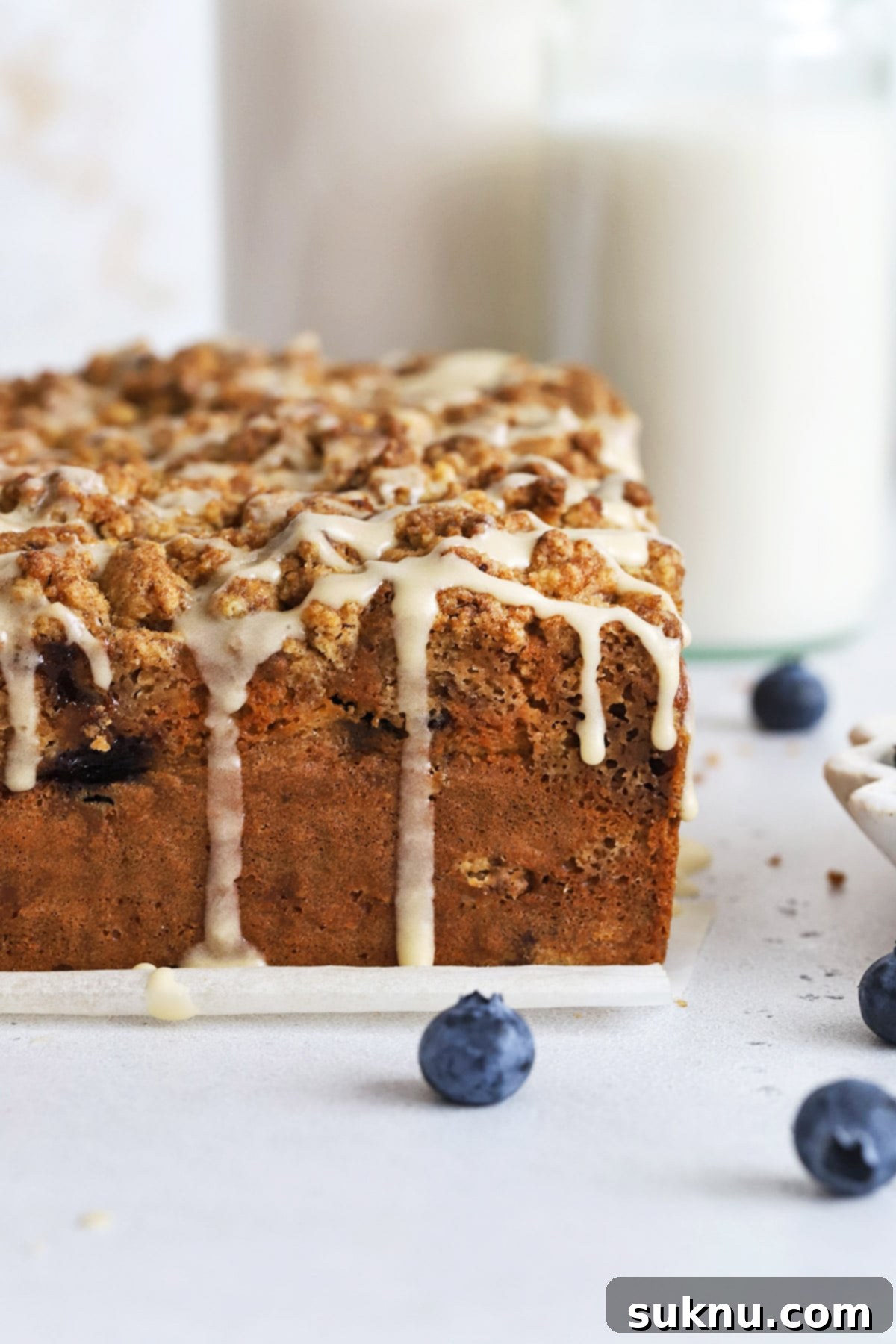 Drizzling gluten-free blueberry coffee cake with glaze