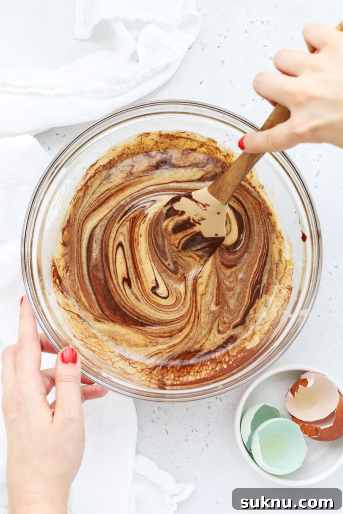 Gently folding melted chocolate into the brownie cookie batter.