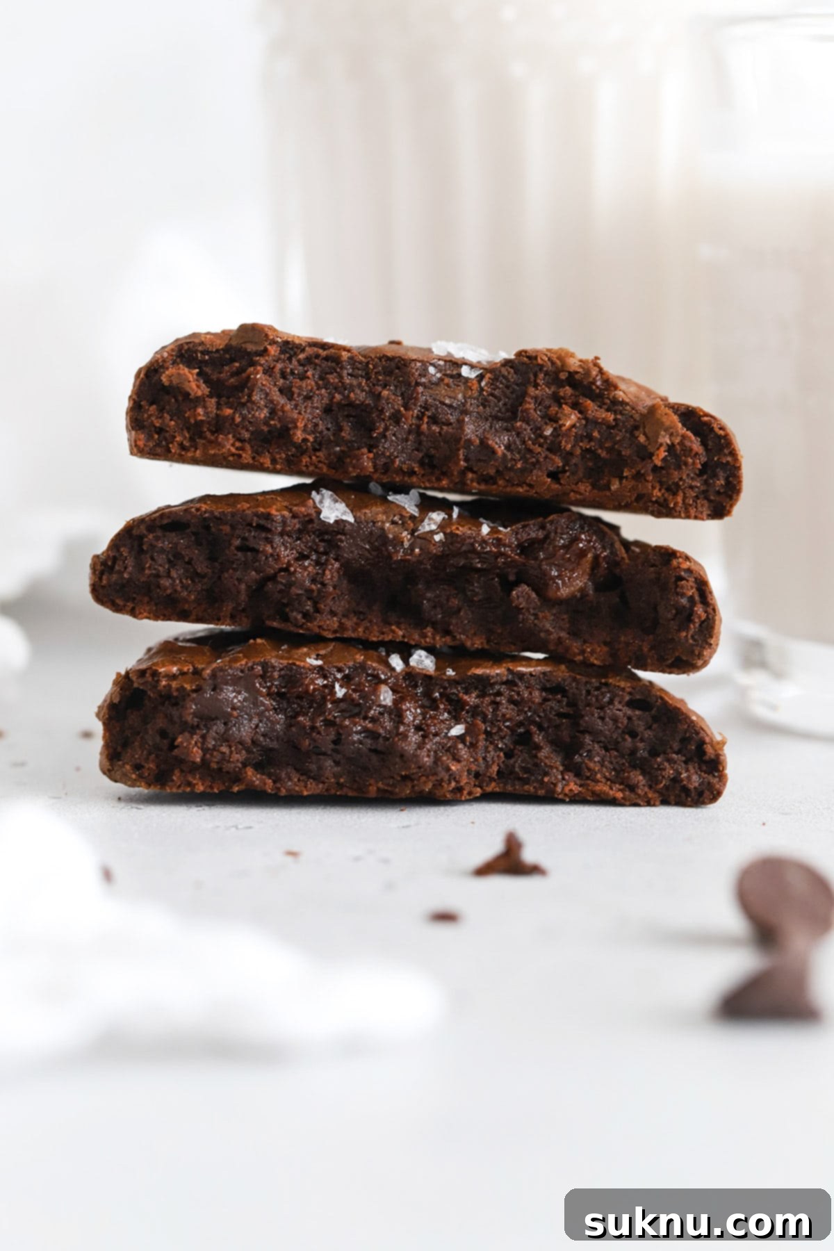 Gluten-free chocolate brownie cookie broken in half, revealing its rich, fudgy center.