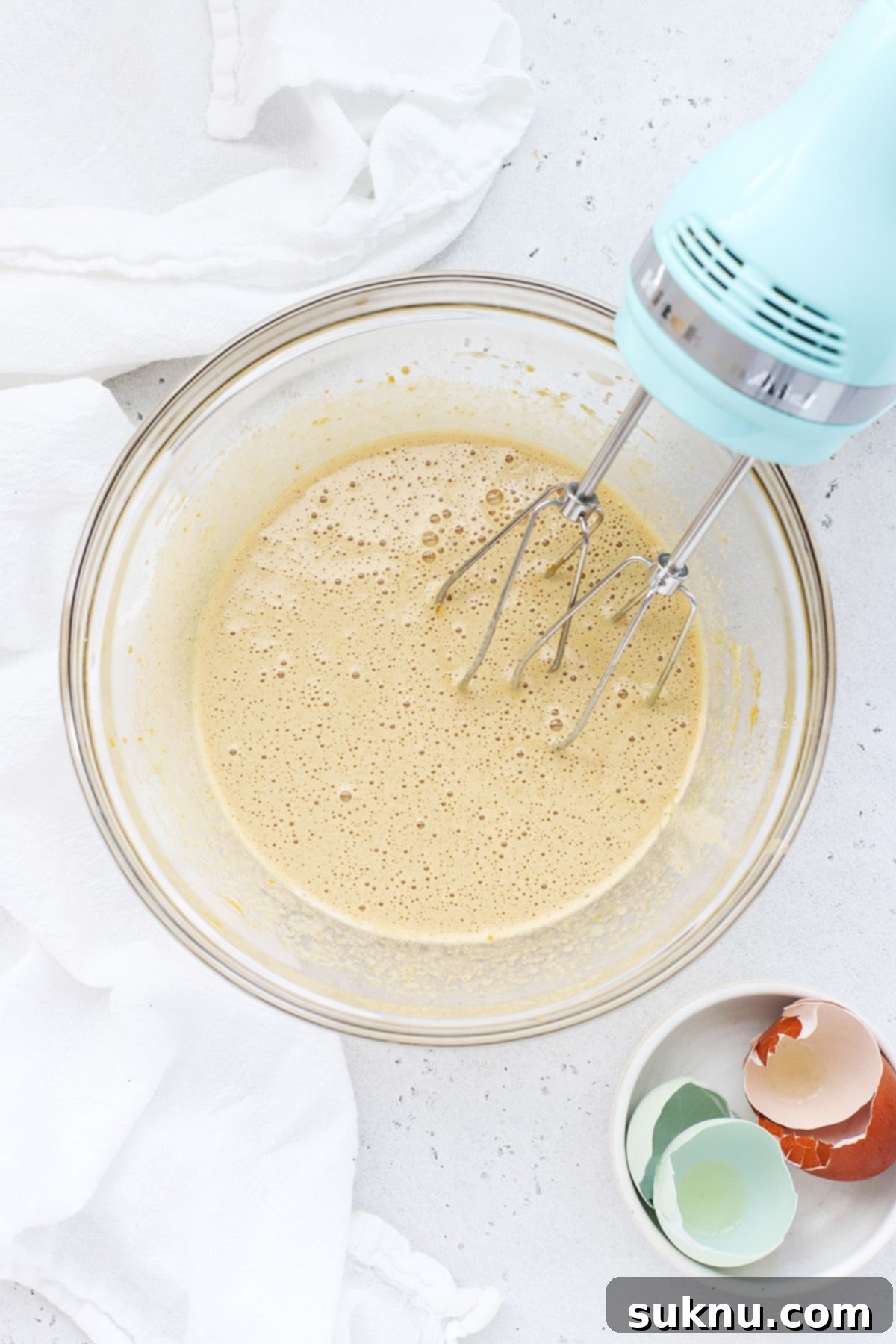 Close-up of fluffy, lightened eggs and sugar mixture after whisking for brownie cookies.