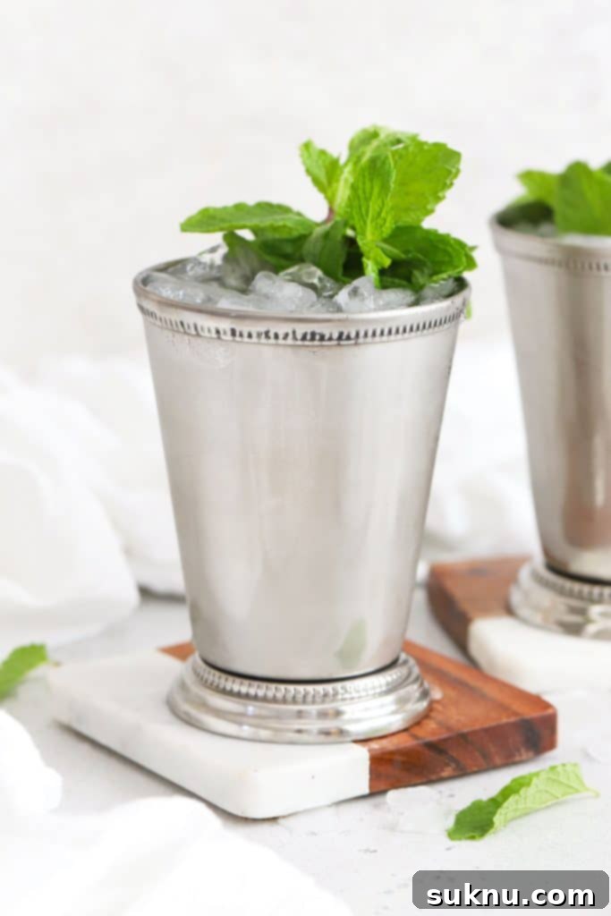 Zesty Mint Lime Mocktail 14 Two non-alcoholic mint juleps served in traditional metal julep cups, garnished with mint sprigs.