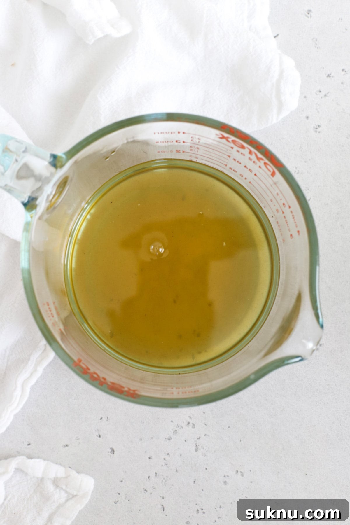 Zesty Mint Lime Mocktail 8 Clear, strained mint simple syrup in a glass measuring cup, ready for use in virgin mojitos.