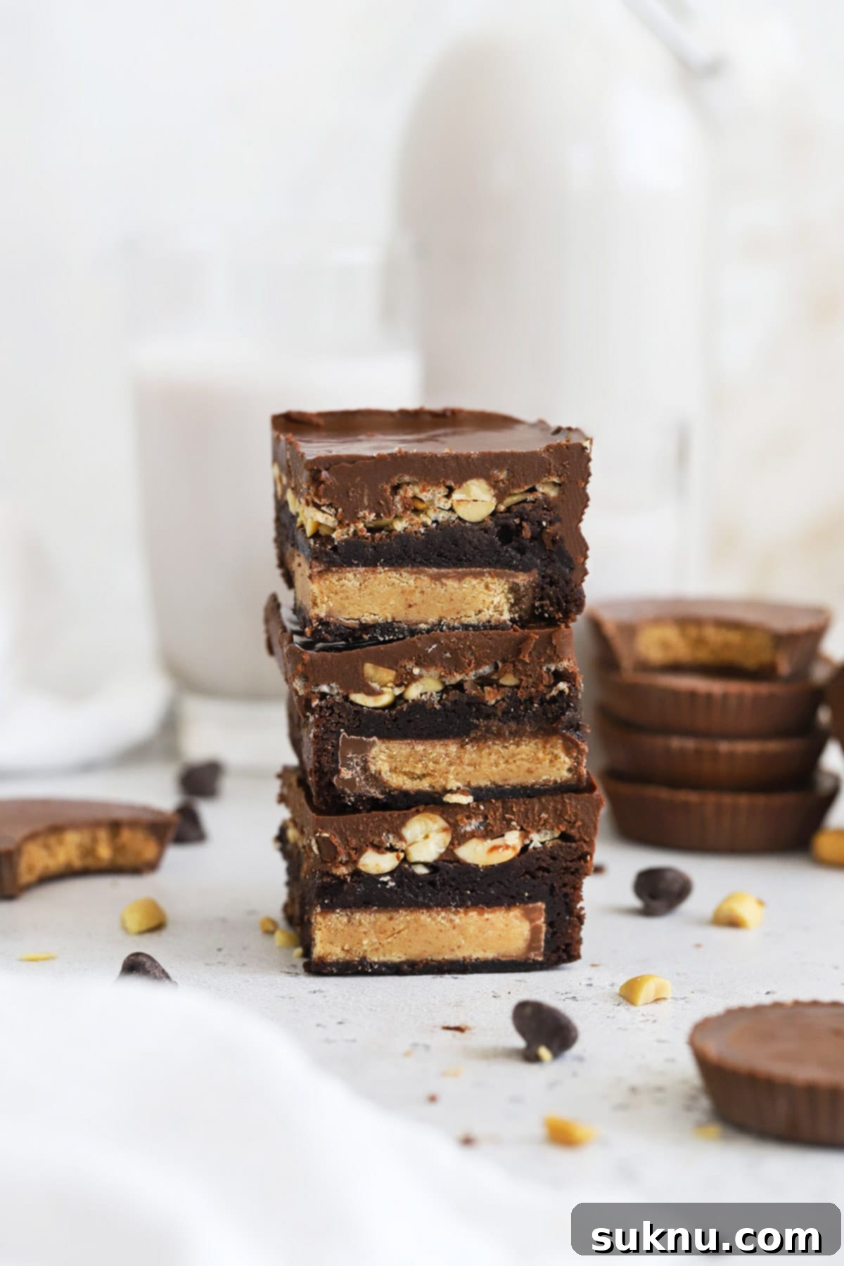 Stacked fudgy gluten-free peanut butter cup brownies with a rich chocolate peanut butter crispy layer, ready to be enjoyed.