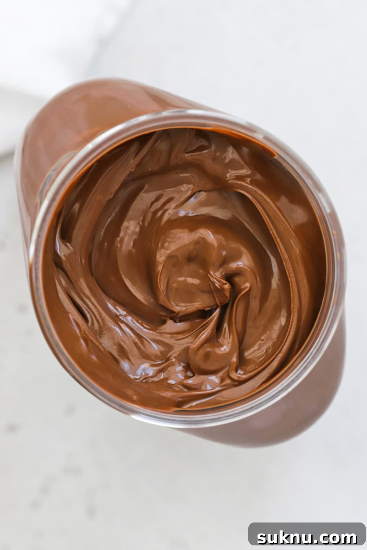 An overhead view of a jar of creamy Nutella, showcasing its rich texture and inviting color, ready to be used in baking.