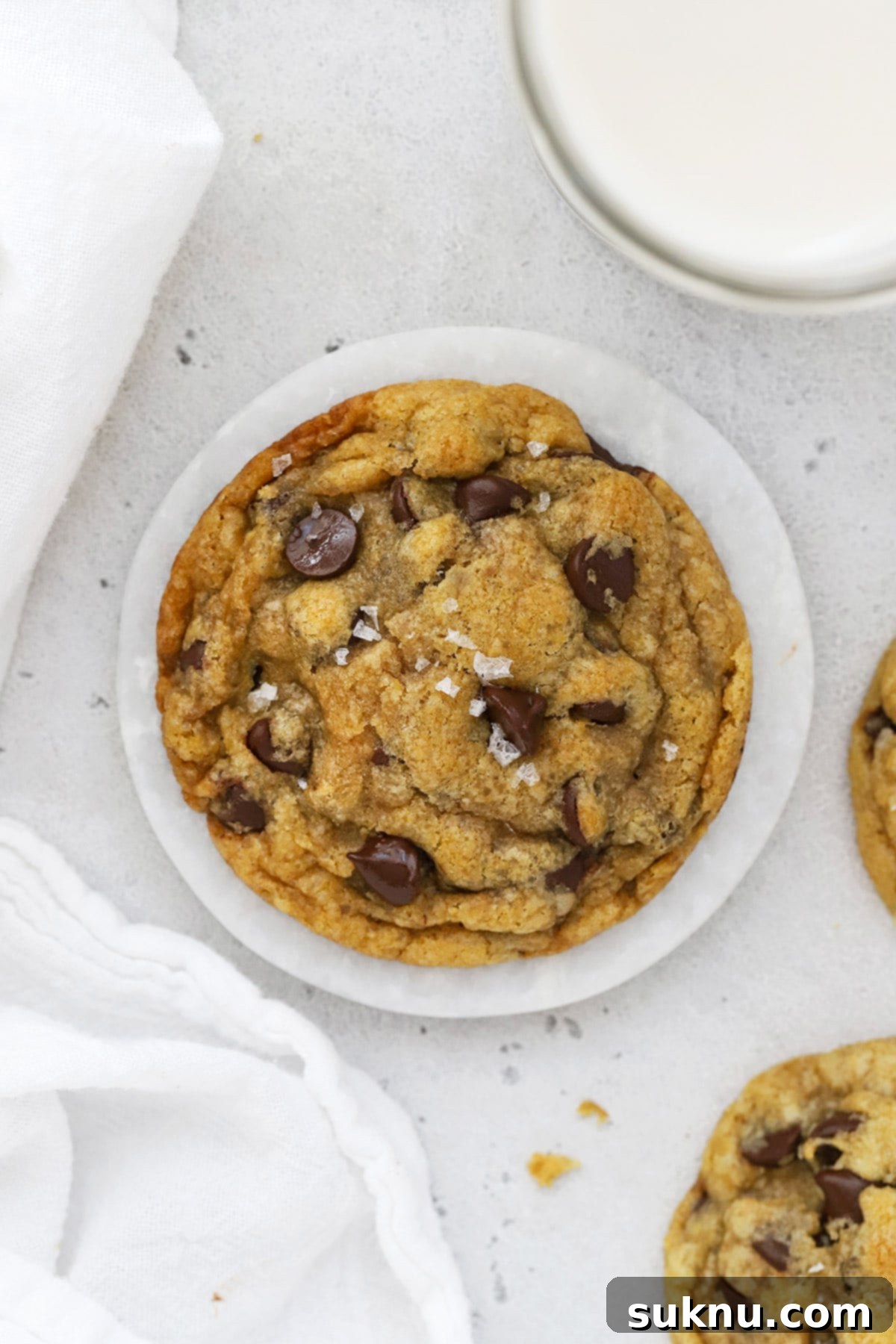 An overhead shot of deliciously baked gluten-free brown butter chocolate chip cookies, stuffed with Nutella, arranged beautifully on a cooling rack.