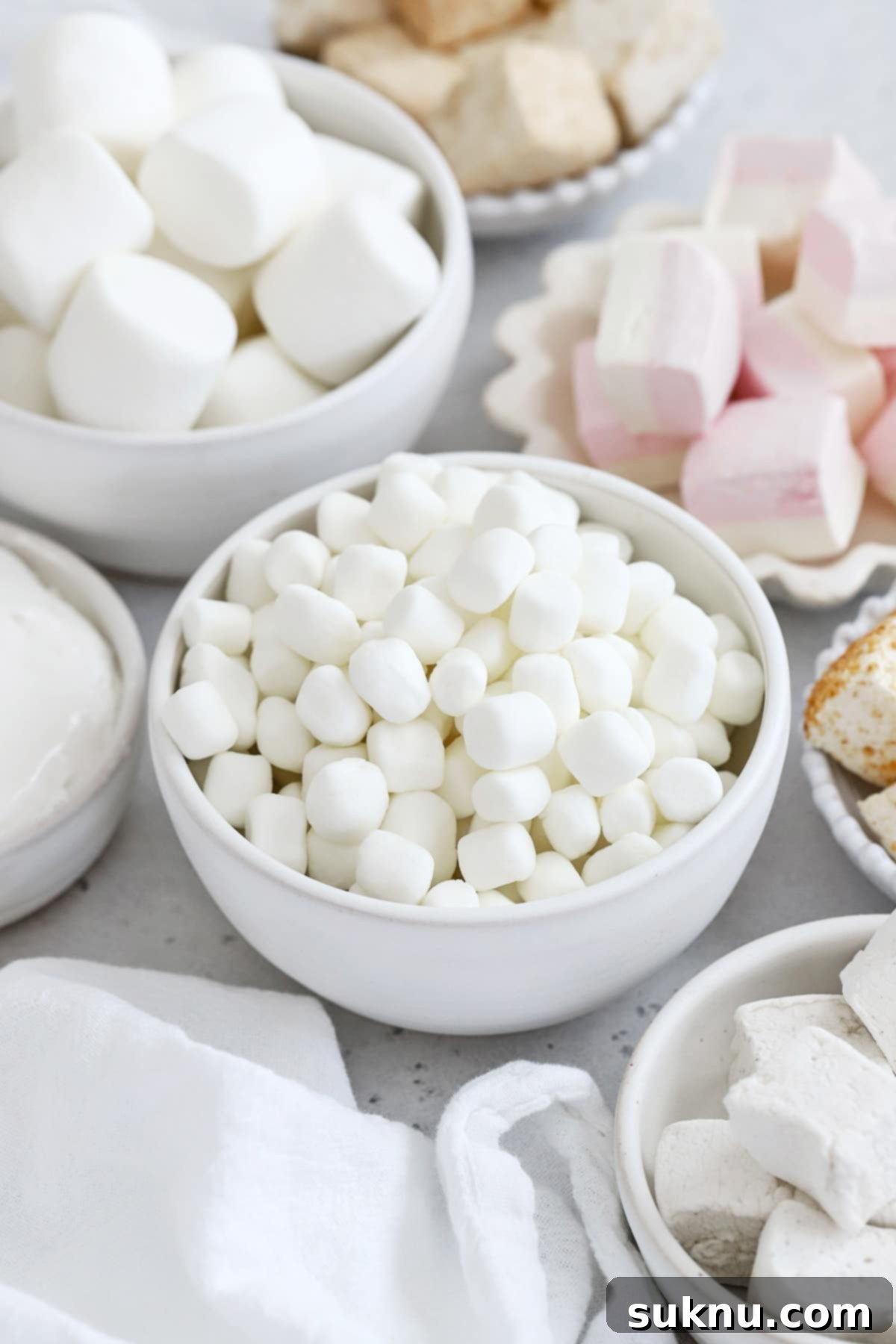 Front view of several bowls of gluten-free marshmallows in different sizes, flavors, and shapes