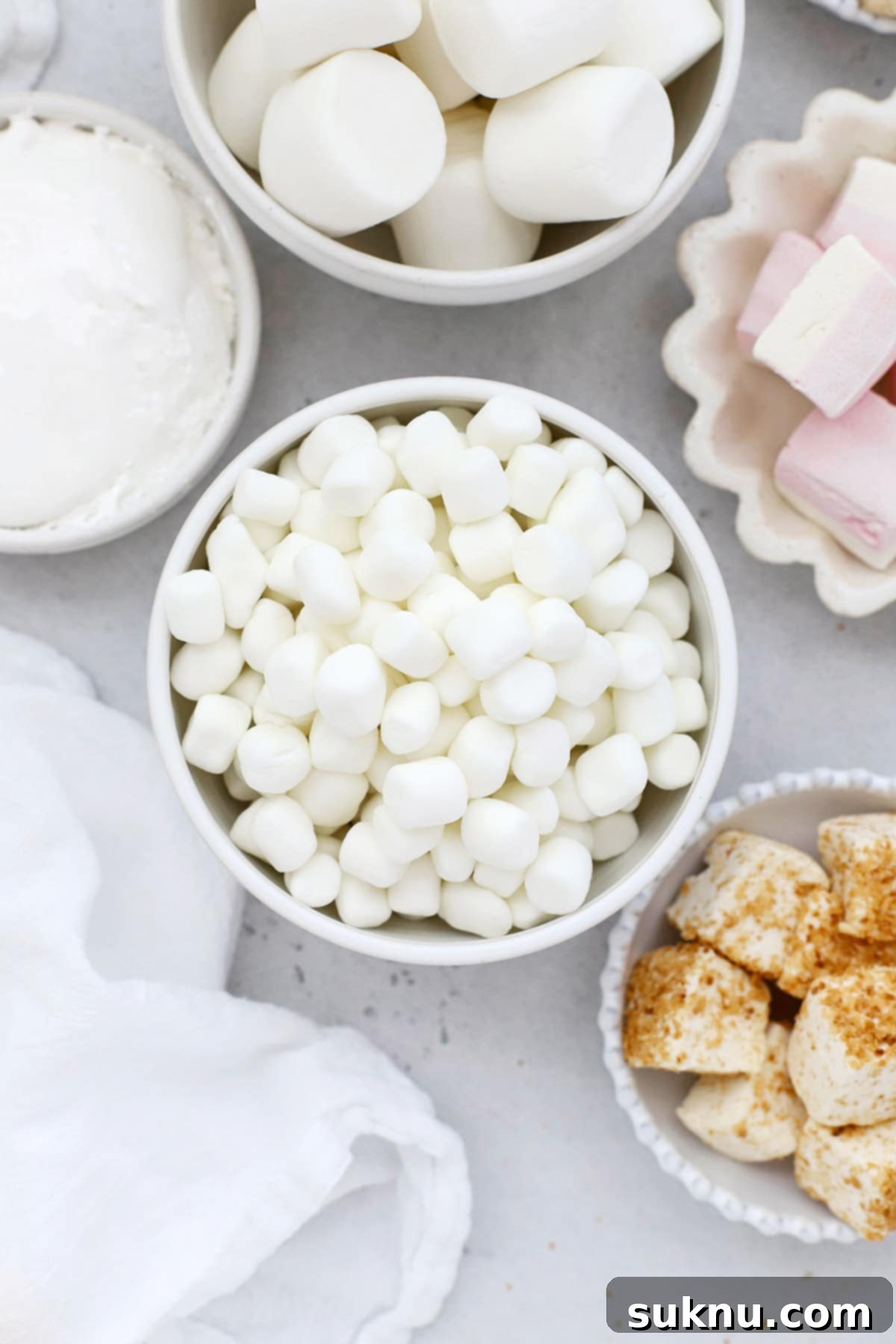 Overhead view of several bowls of marshmallows in different shapes, sizes, and flavors