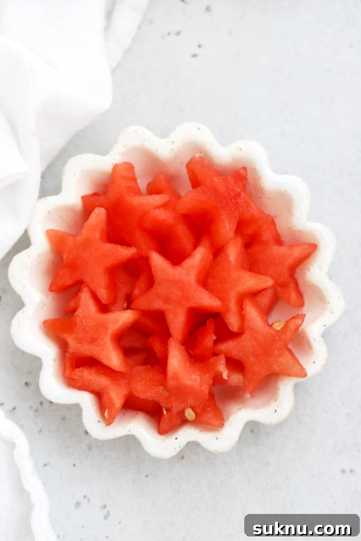 Overhead view of watermelon star cutouts in a white ruffled dish