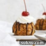 Front view of gluten-free fried ice cream topped with whipped cream, chocolate syrup, and a maraschino cherry