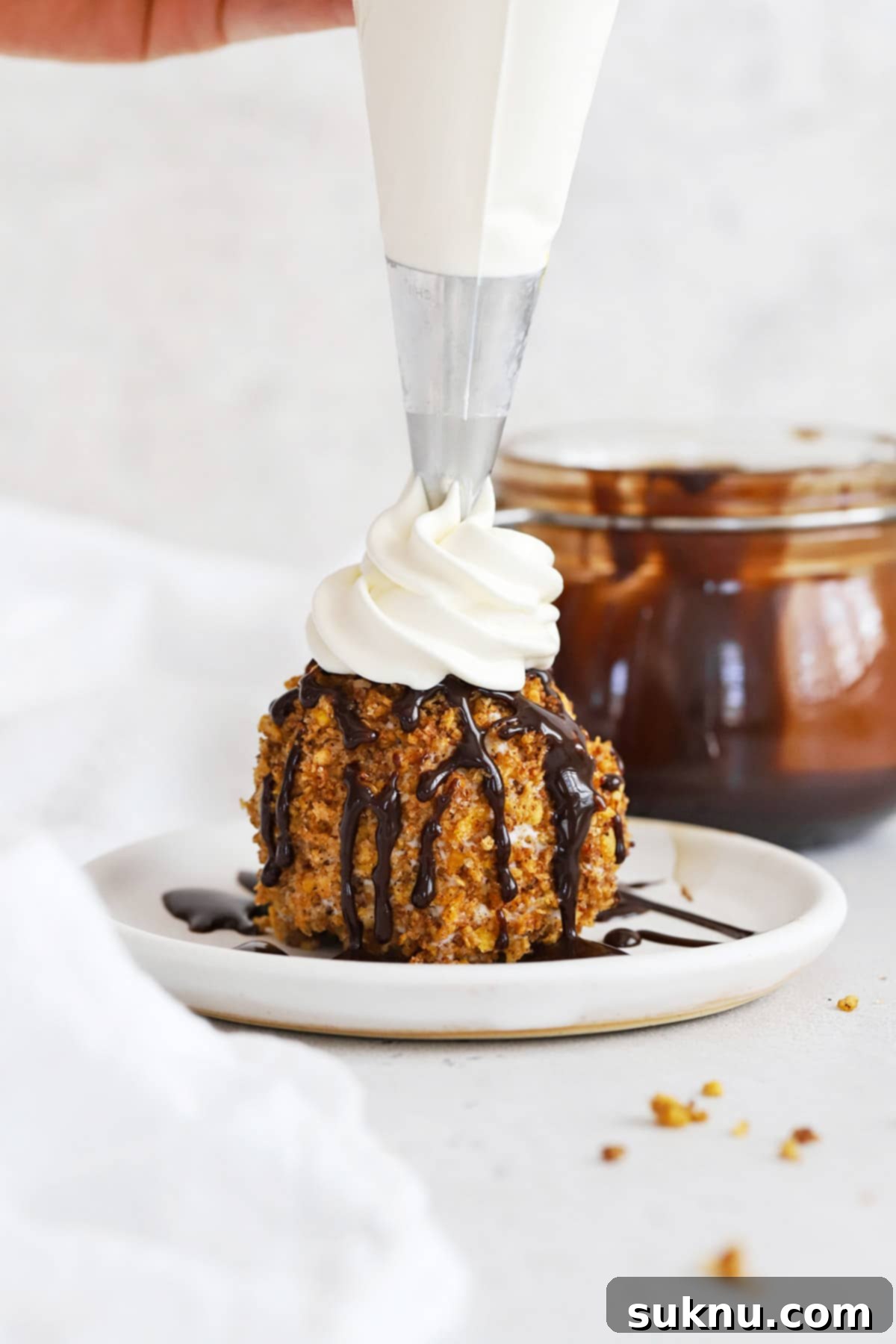 Adding whipped cream to gluten-free fried ice cream