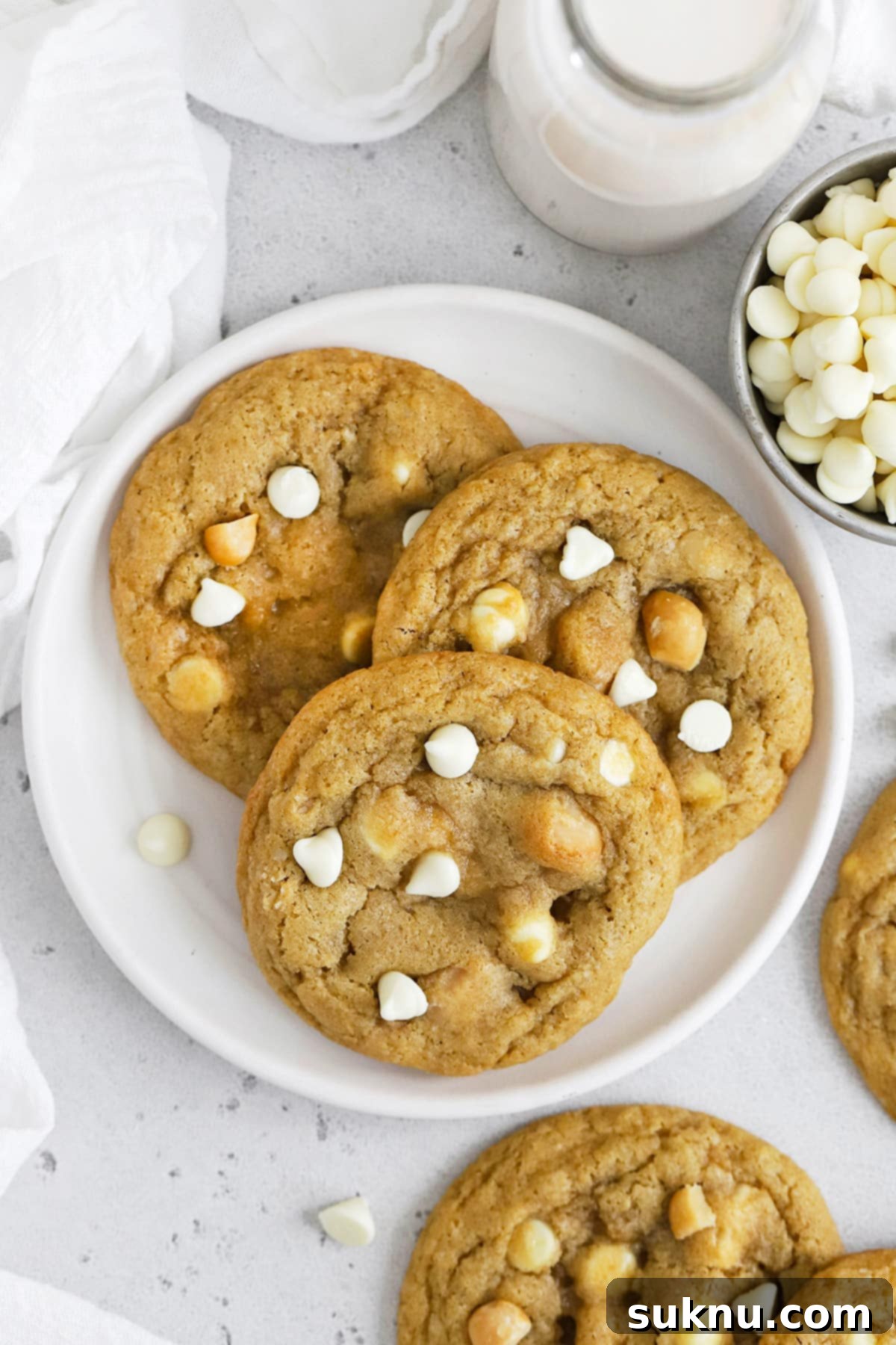 Overhead view of three gluten-free white chocolate chip macadamia nut cookies on a plate