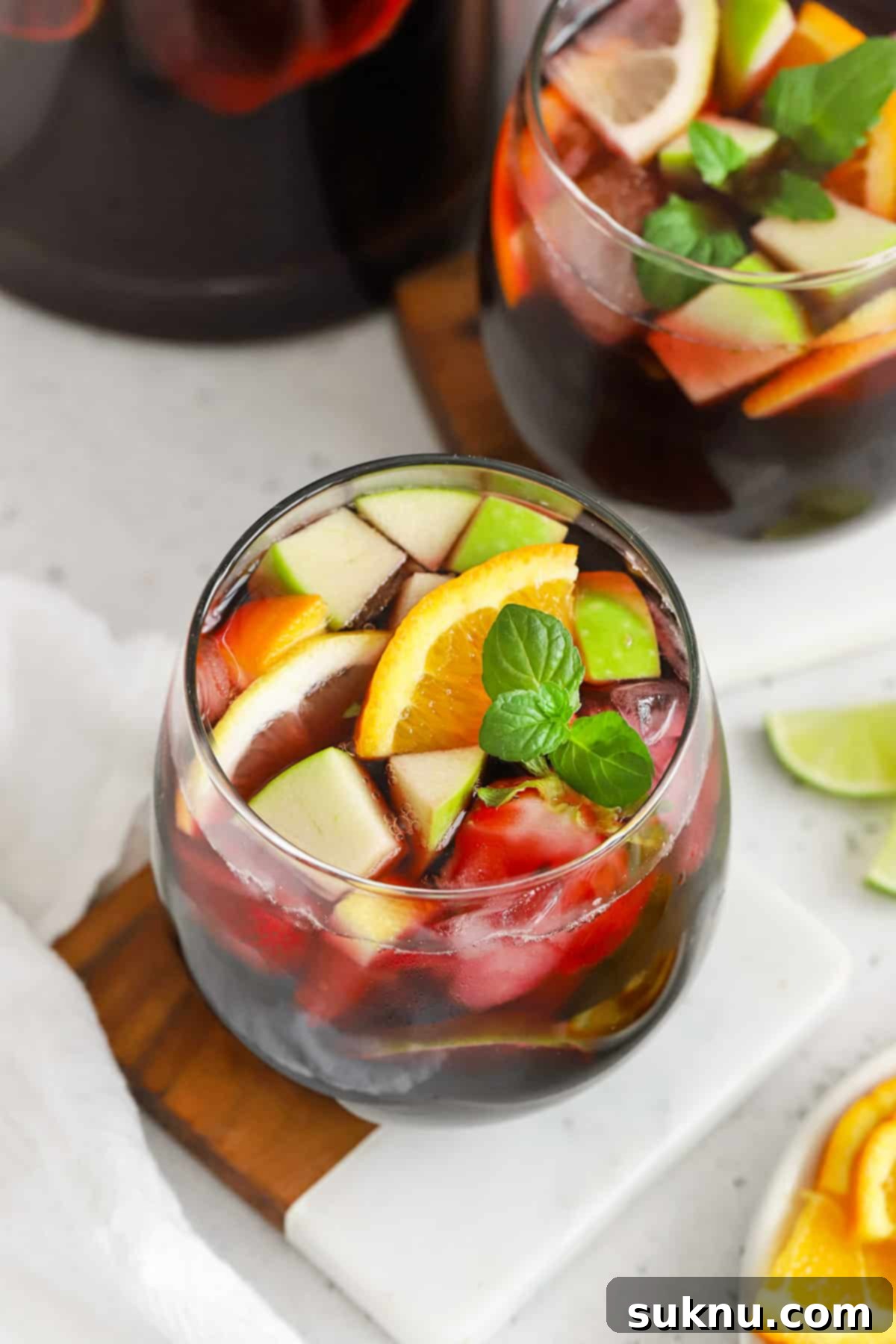 Overhead view of a glass of non-alcoholic sangria with fresh fruit, including orange slices and berries