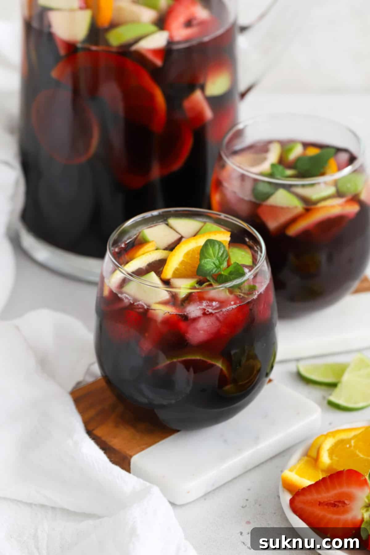 Front view of two stemless glasses of non-alcoholic sangria, with a warm, inviting glow