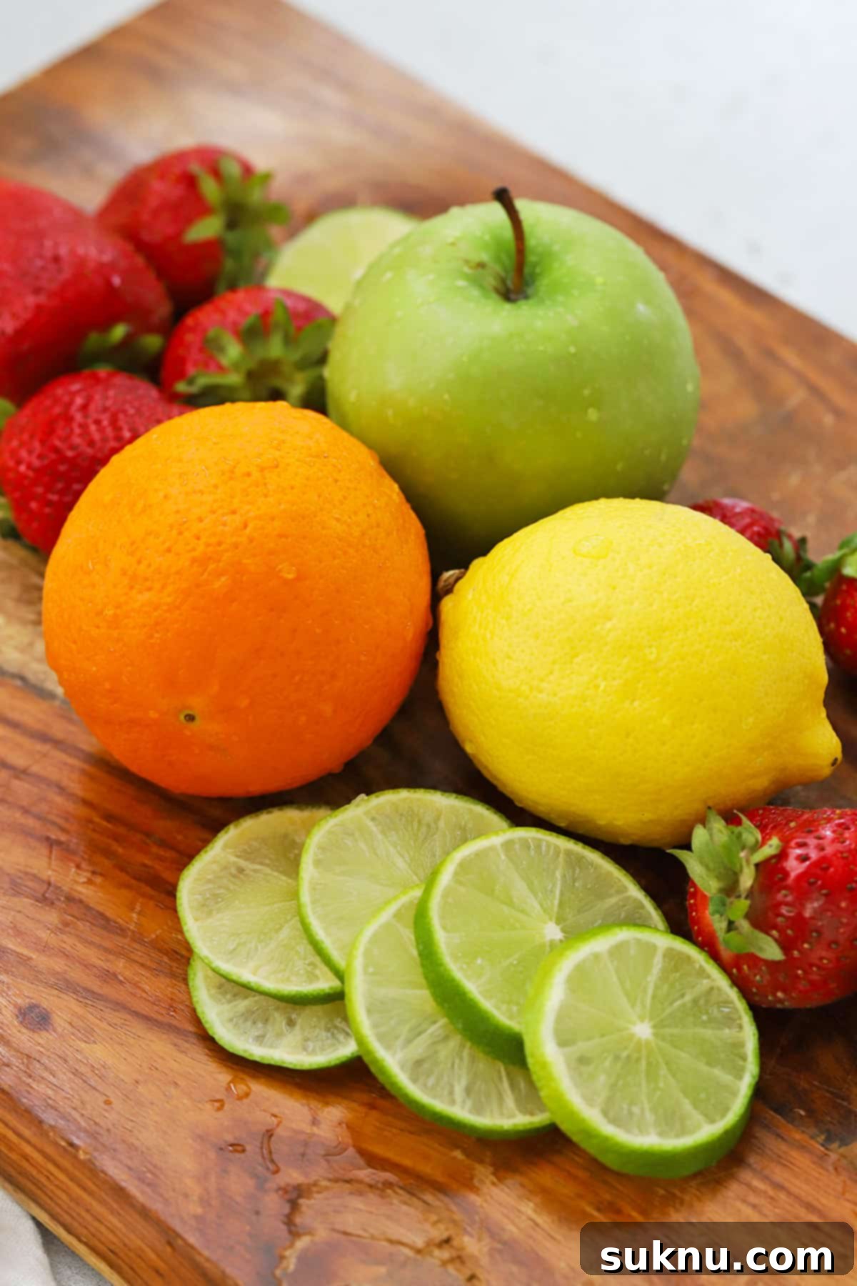 Front view of fresh fruit for non-alcoholic sangria, including oranges, limes, lemons, and strawberries