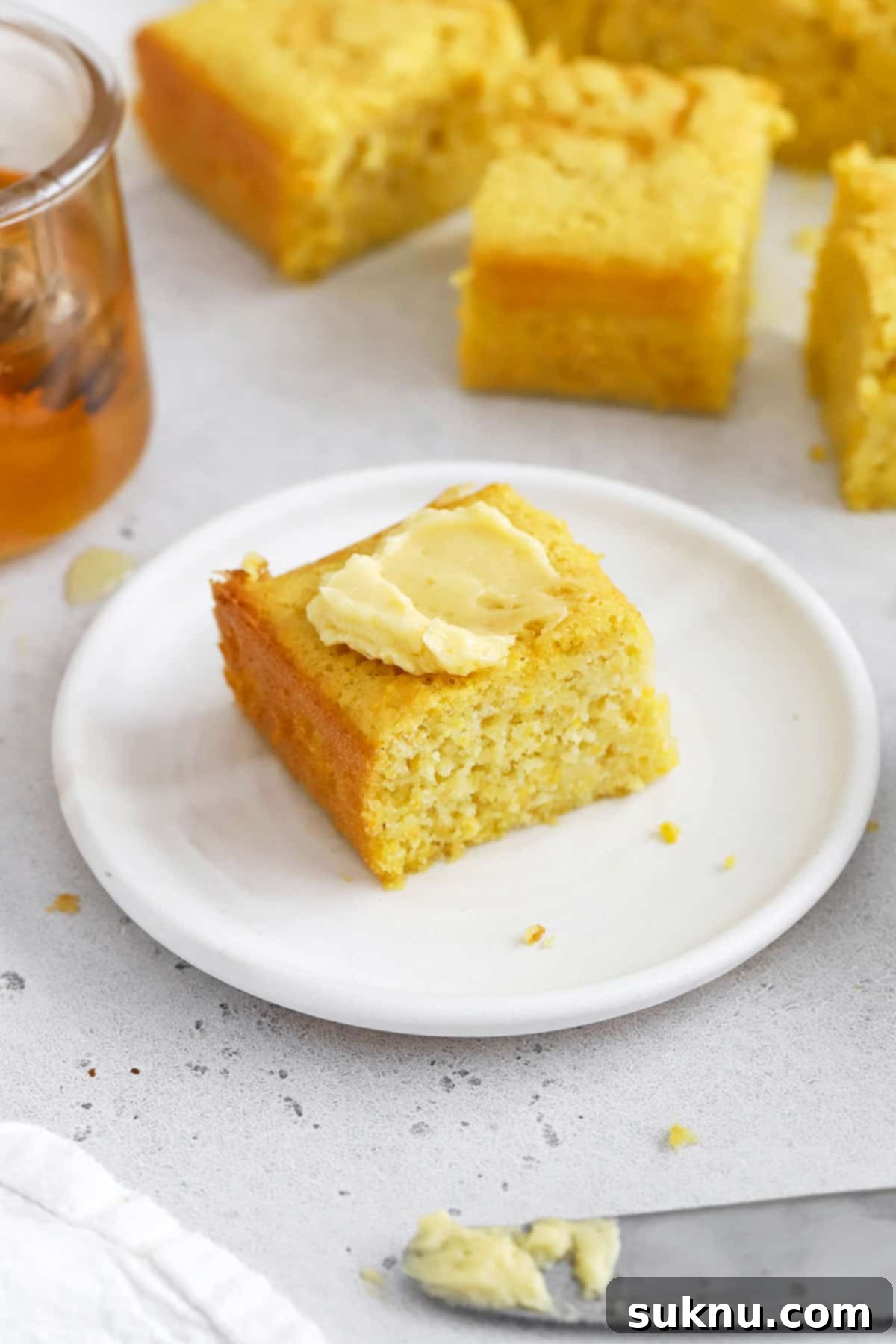 Fluffy Honey Butter Made in Minutes 9 Front view of a slice of easy gluten-free cornbread topped with honey butter
