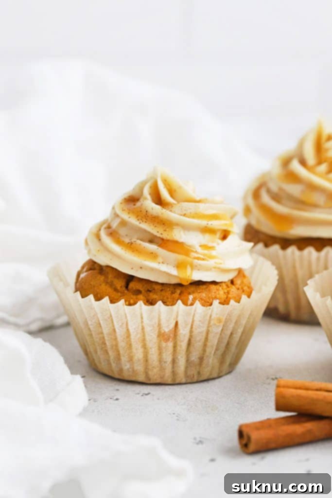 Delightful gluten-free pumpkin cupcakes with cinnamon cream cheese frosting and a caramel drizzle.