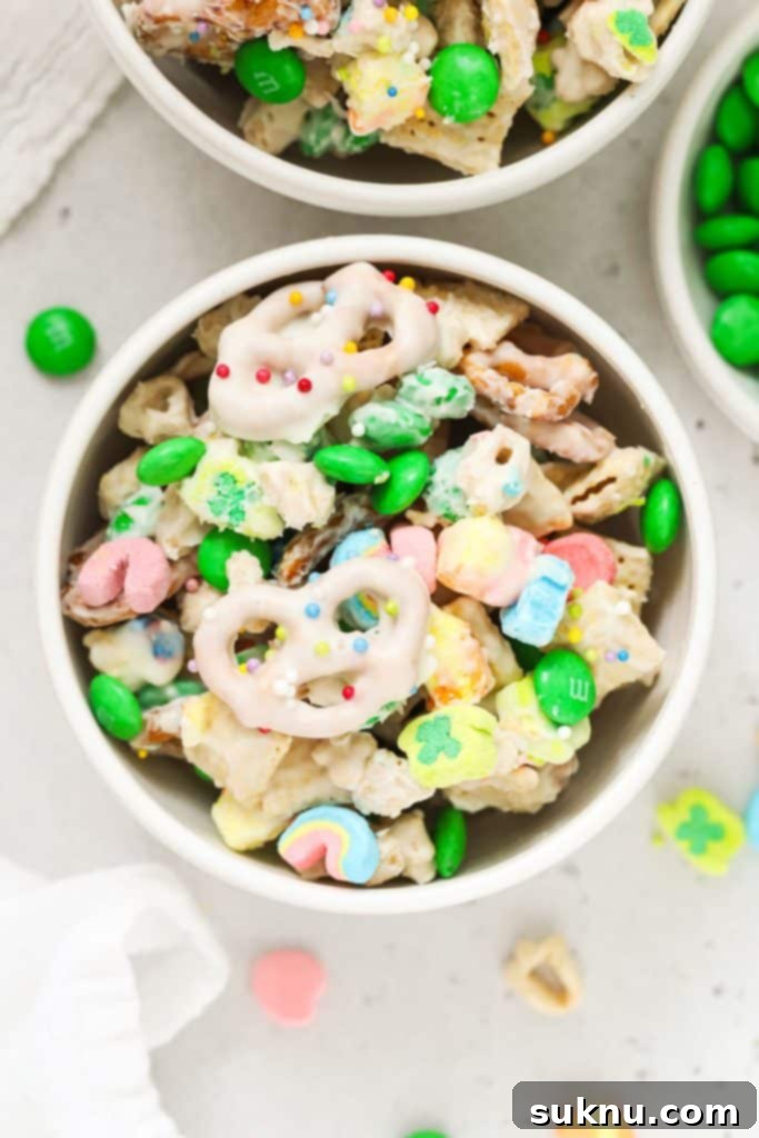 Bowls of festive leprechaun bait snack mix alongside a bowl of green M&Ms, ideal for St. Patrick's Day.