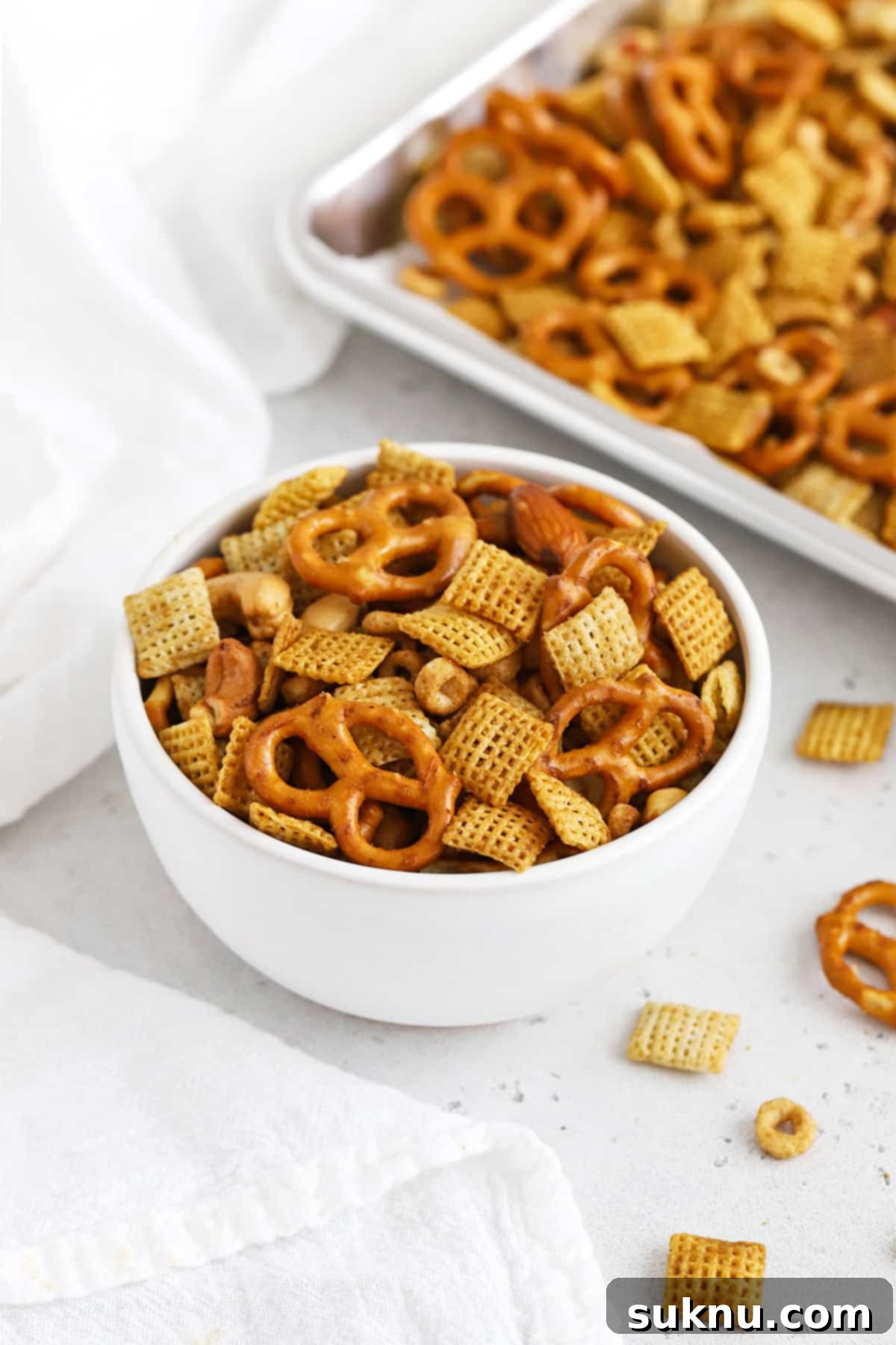 Front view of a bowl of easy gluten-free Chex Mix on a white background, ready to be served and enjoyed.
