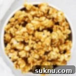 Overhead view of one white bowl of homemade caramel corn