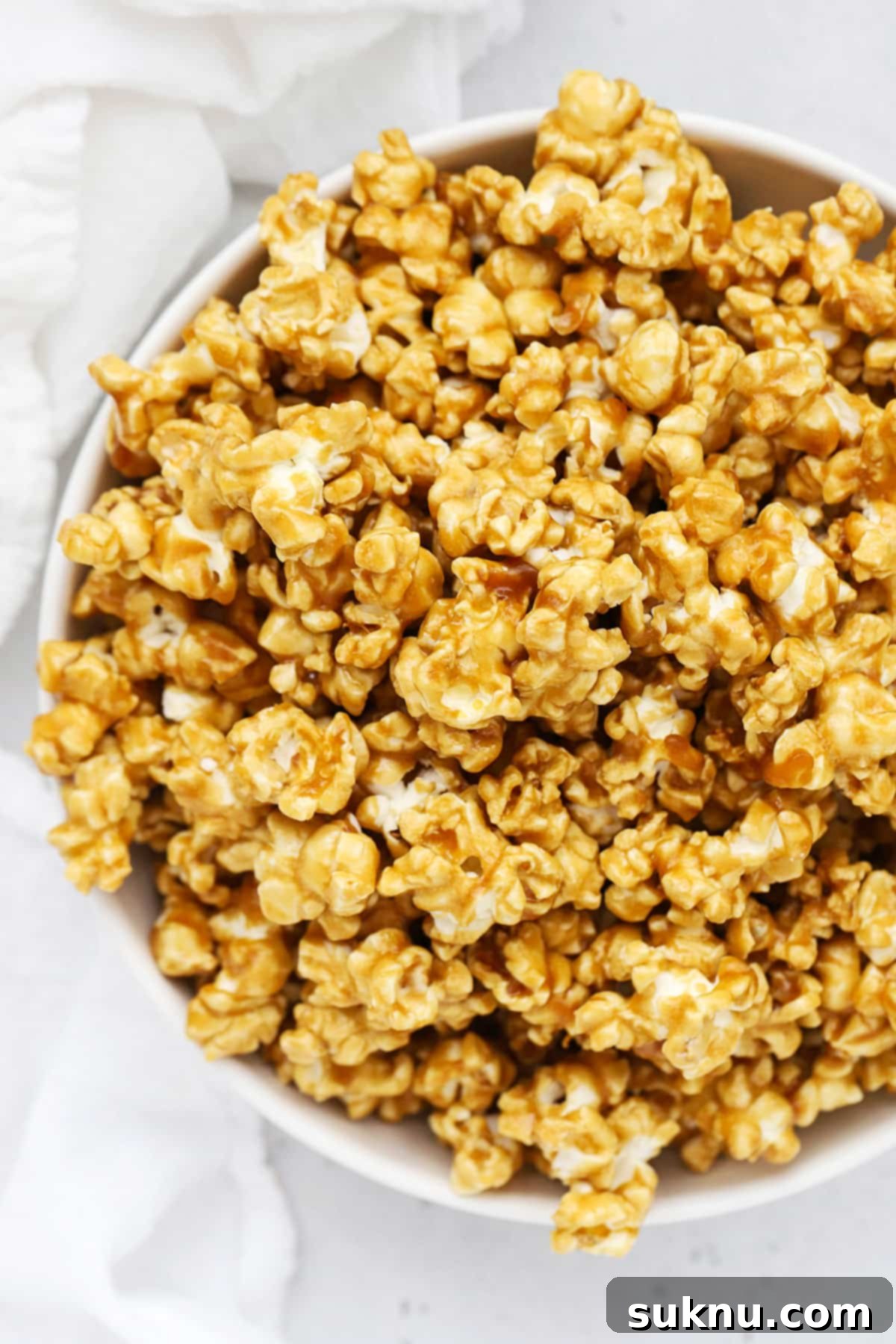 Overhead view of a large white bowl of homemade caramel corn