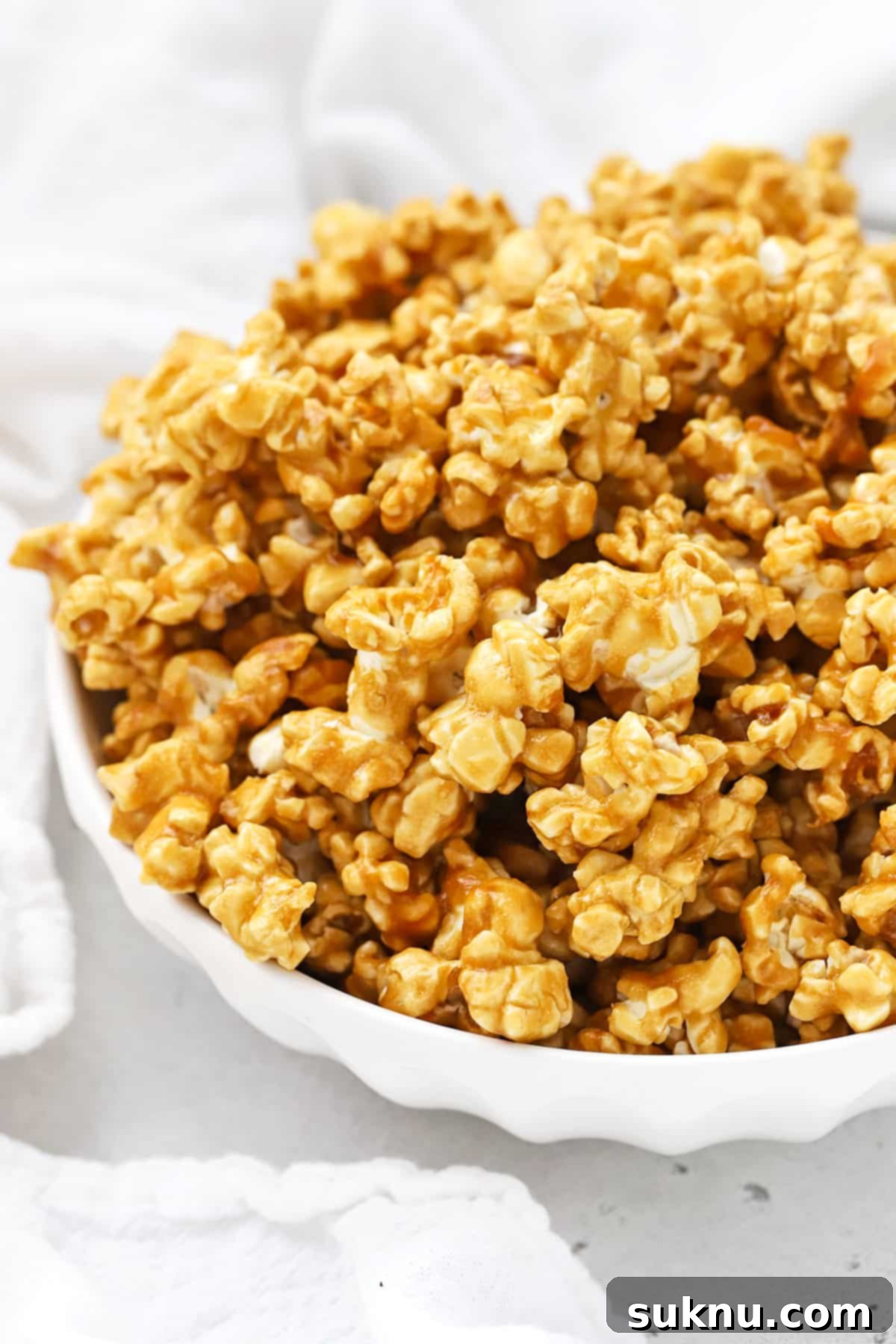 Front view of a large white bowl of homemade caramel corn