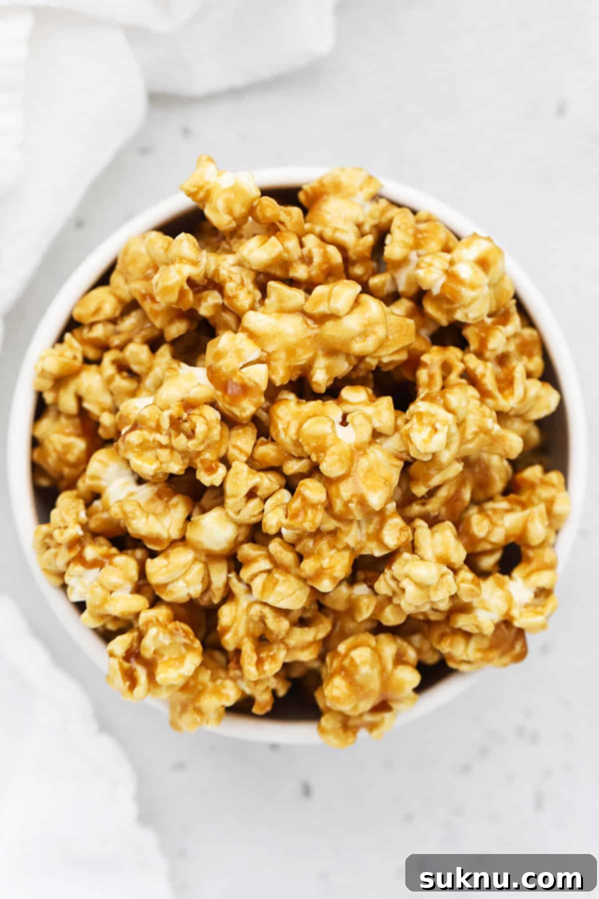 Overhead view of one white bowl of homemade caramel corn