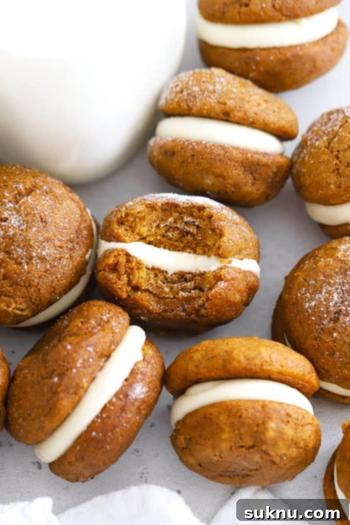 Cozy Fall Gluten-Free Pumpkin Snickerdoodles 12 Gluten-Free Pumpkin Whoopie Pies with Cream Cheese Filling on a white background, inviting and delightful.