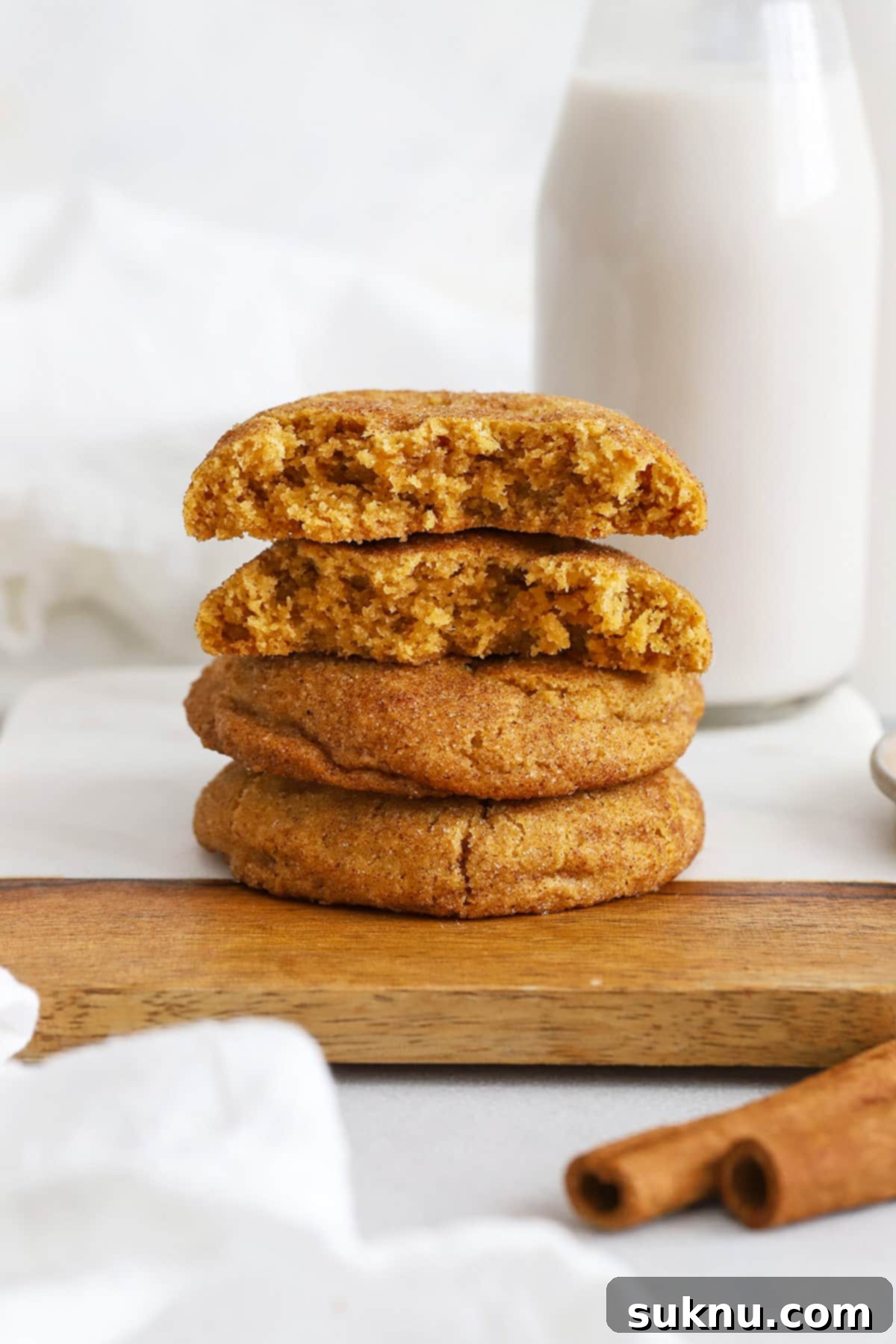Cozy Fall Gluten-Free Pumpkin Snickerdoodles 7 A stack of golden-brown gluten-free pumpkin snickerdoodles with a dusting of cinnamon sugar.